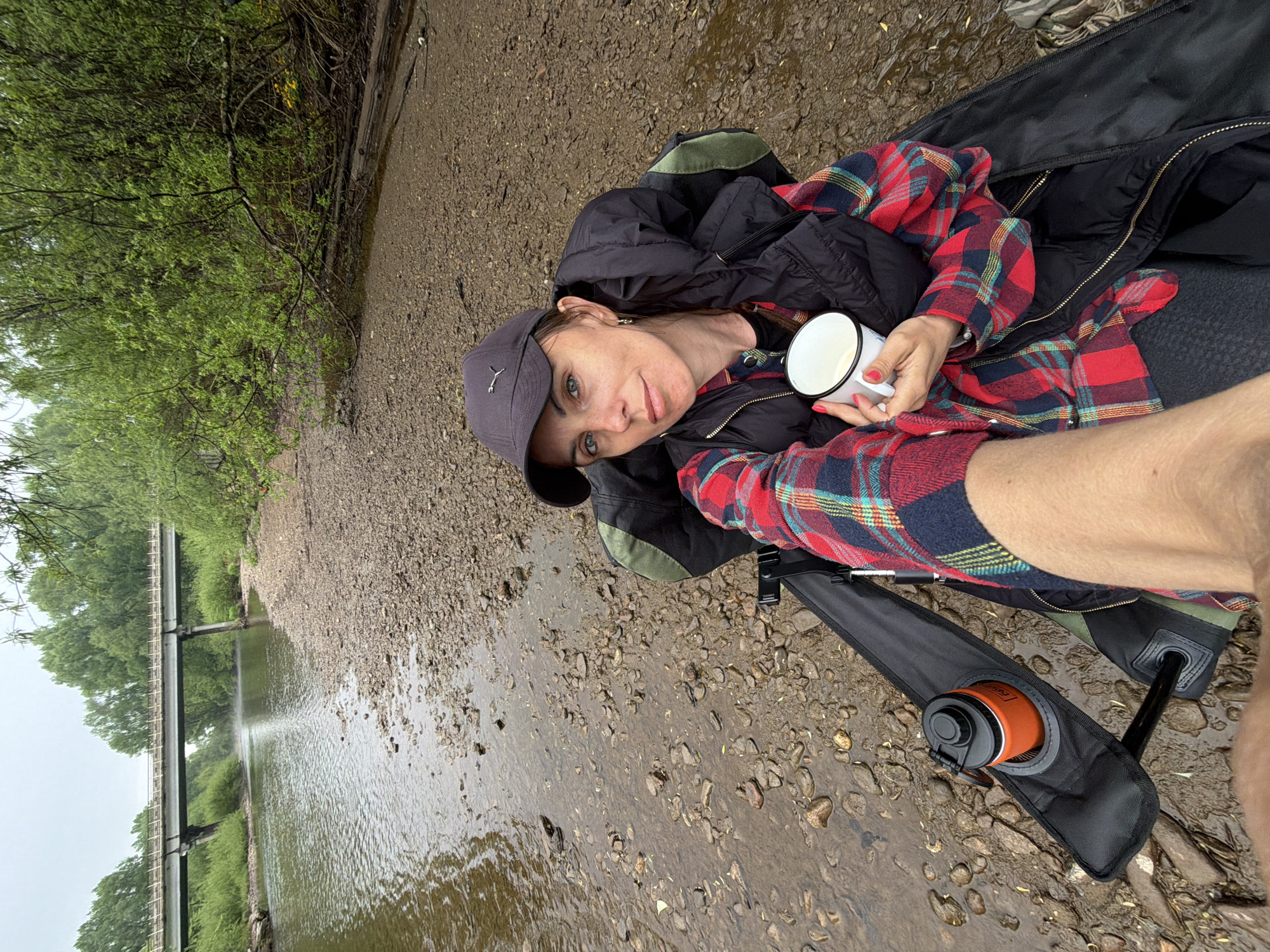 Hiker takes stream break with enamel mug in Russia