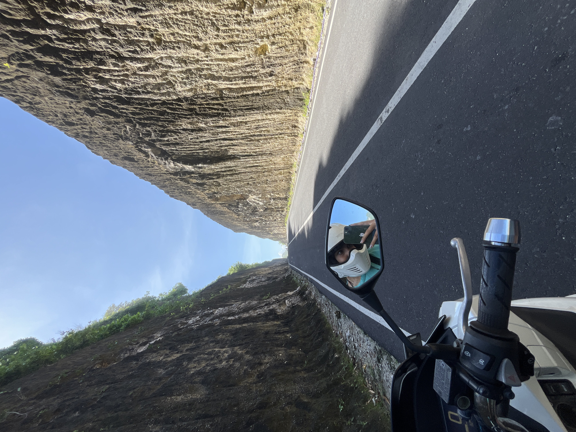 Motorcyclist Takes Selfie on Cliff-Lined Road in Kuta Selatan