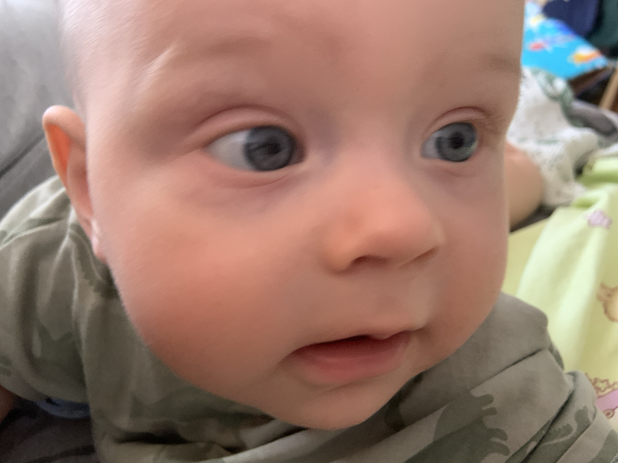 Baby in green camo shirt photographed at home in Kyiv