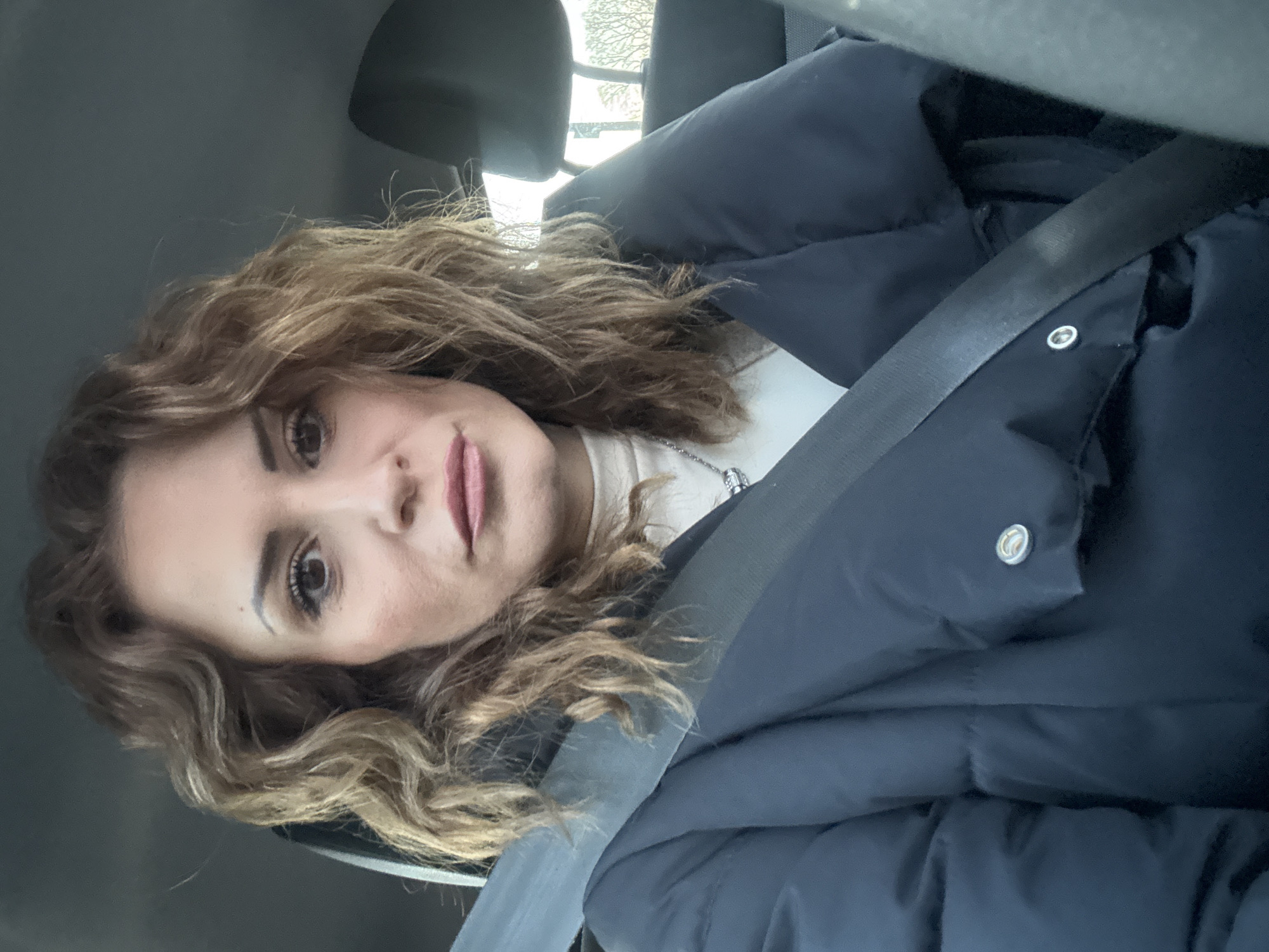 Woman in navy puffer jacket observed in London vehicle