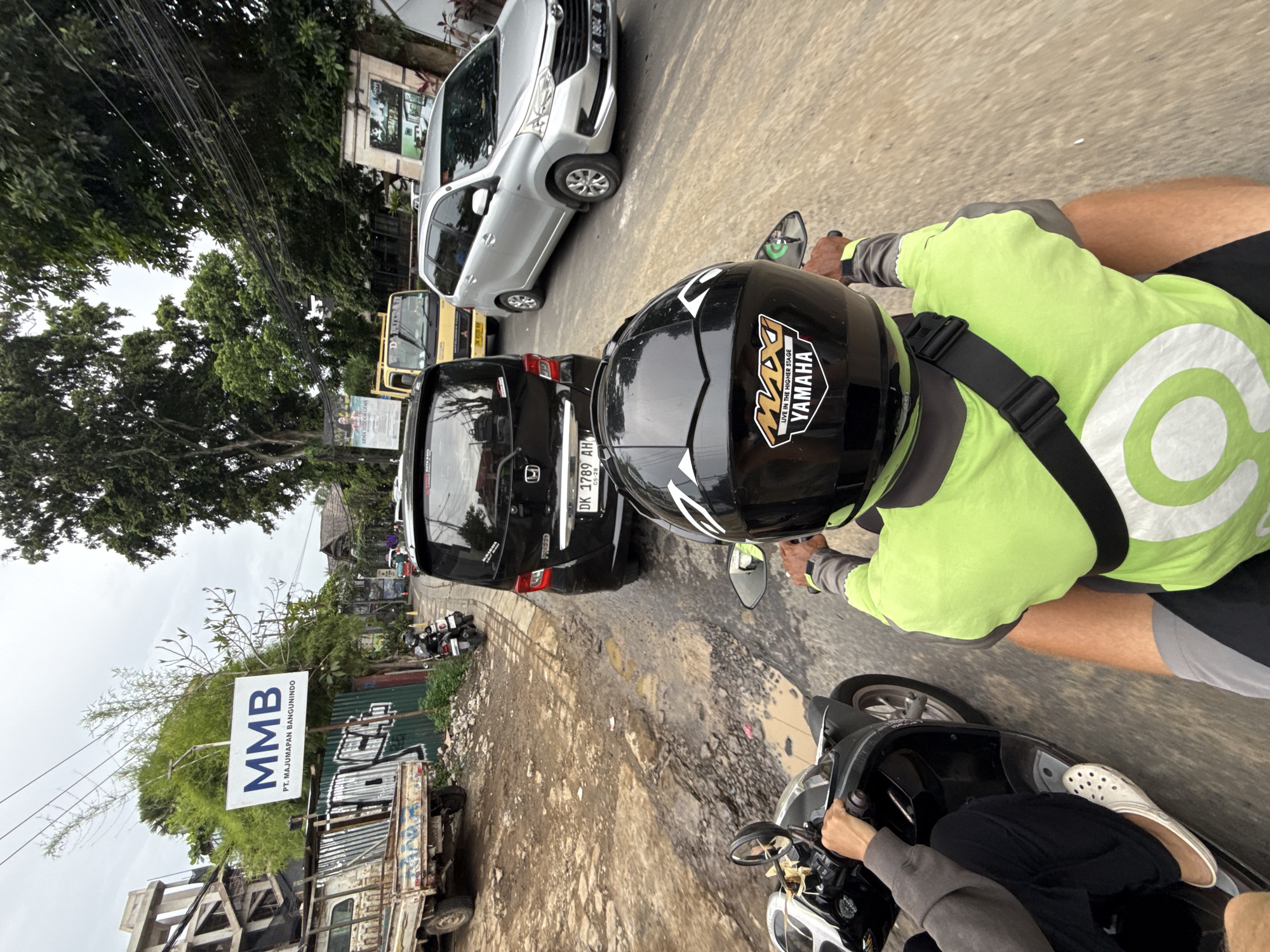Motorcycle rider navigates Ubud streets under overcast skies
