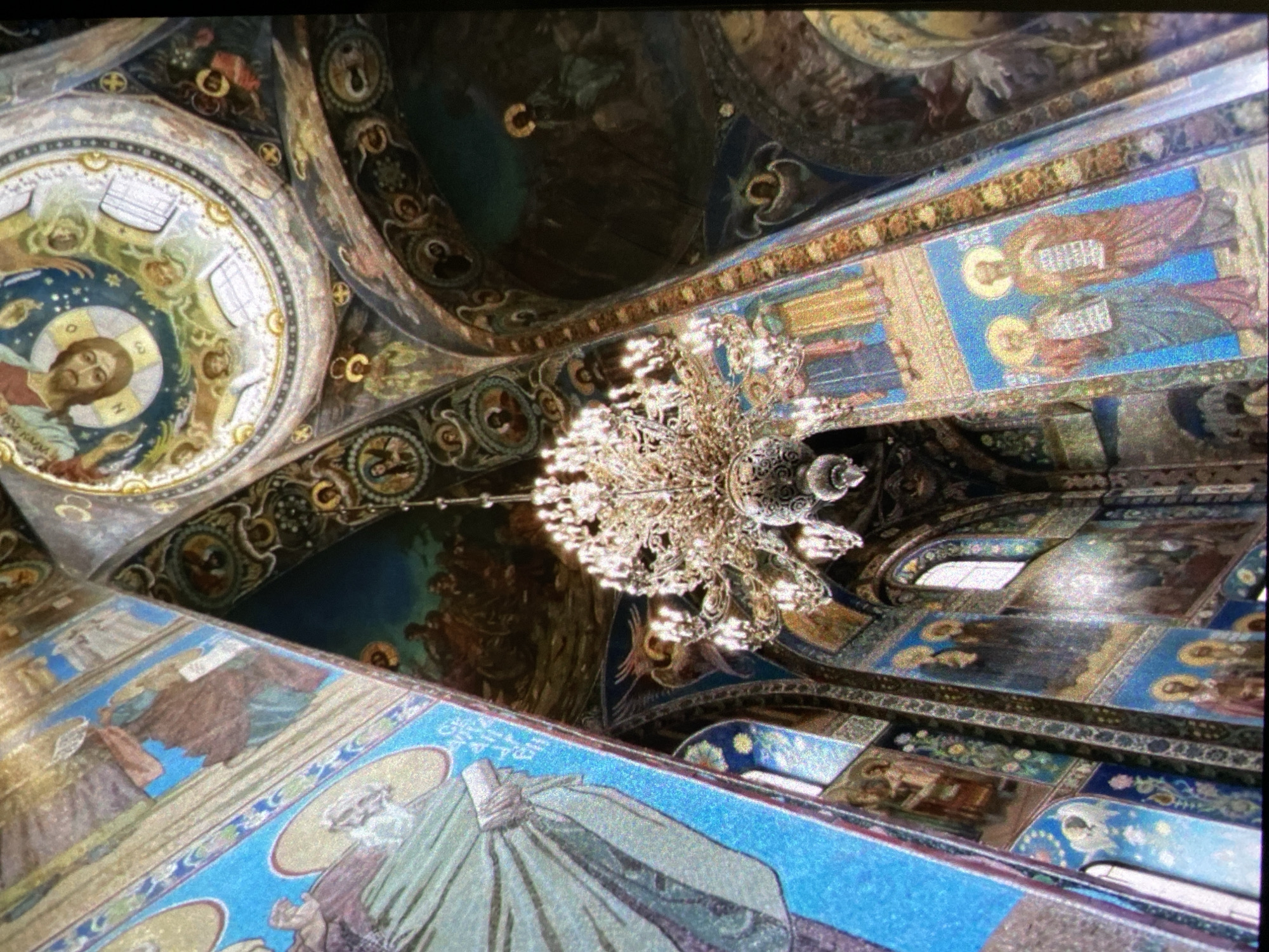 Tourist visits Saint Petersburg's Church of Spilled Blood, Aurora cruiser