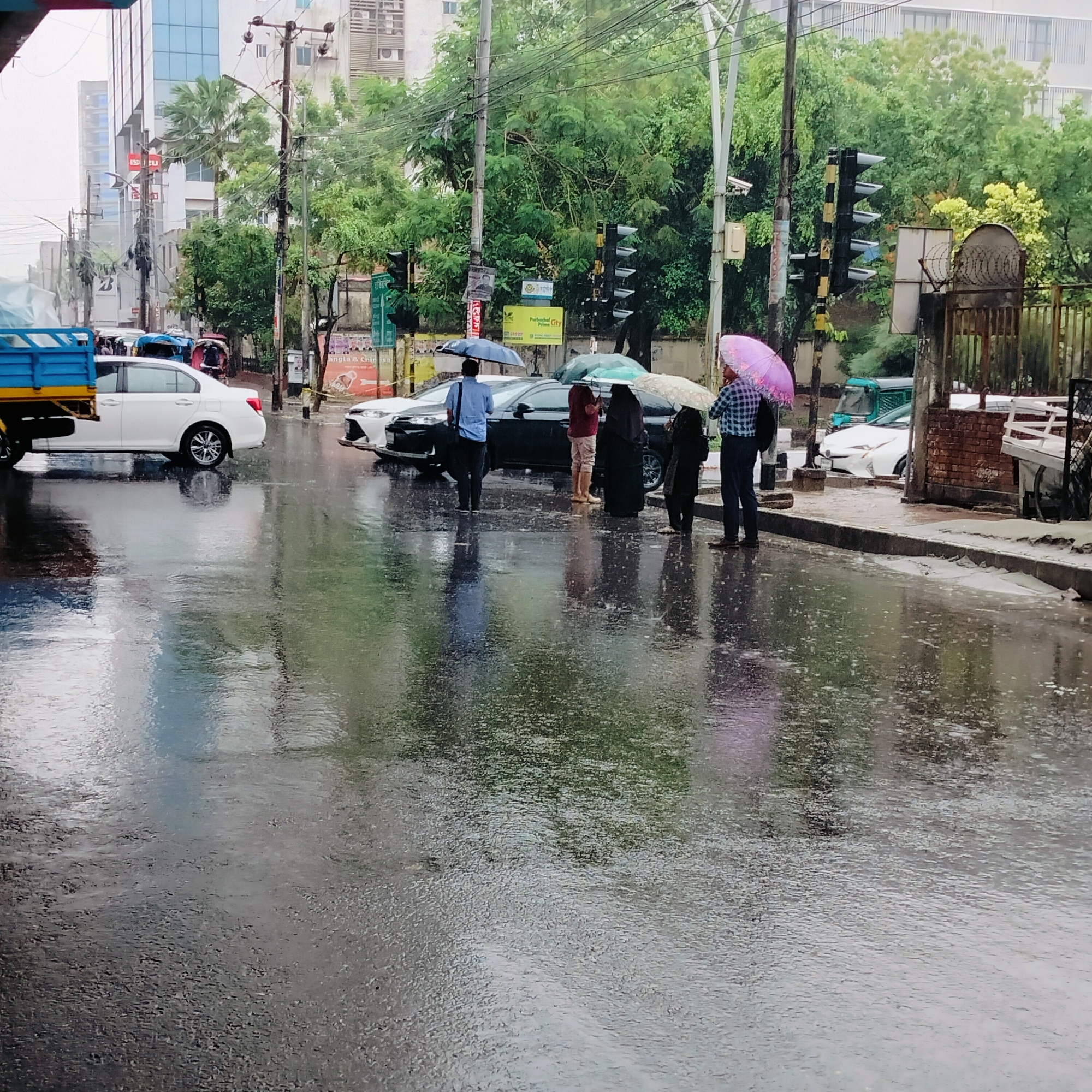 Rain-soaked Dhaka street creates reflective mirror of buildings