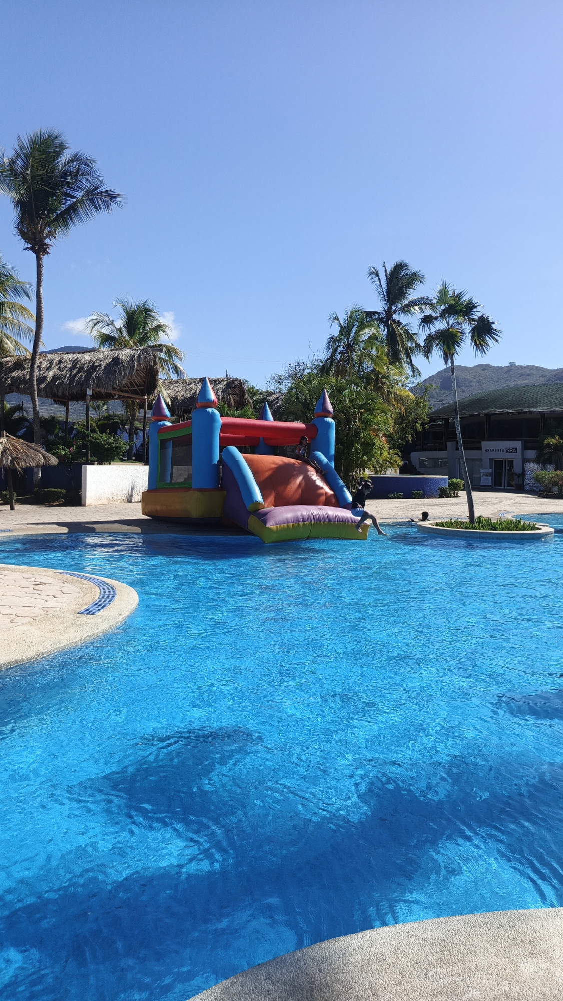 Resort scenes captured at Playa El Agua including costumed character