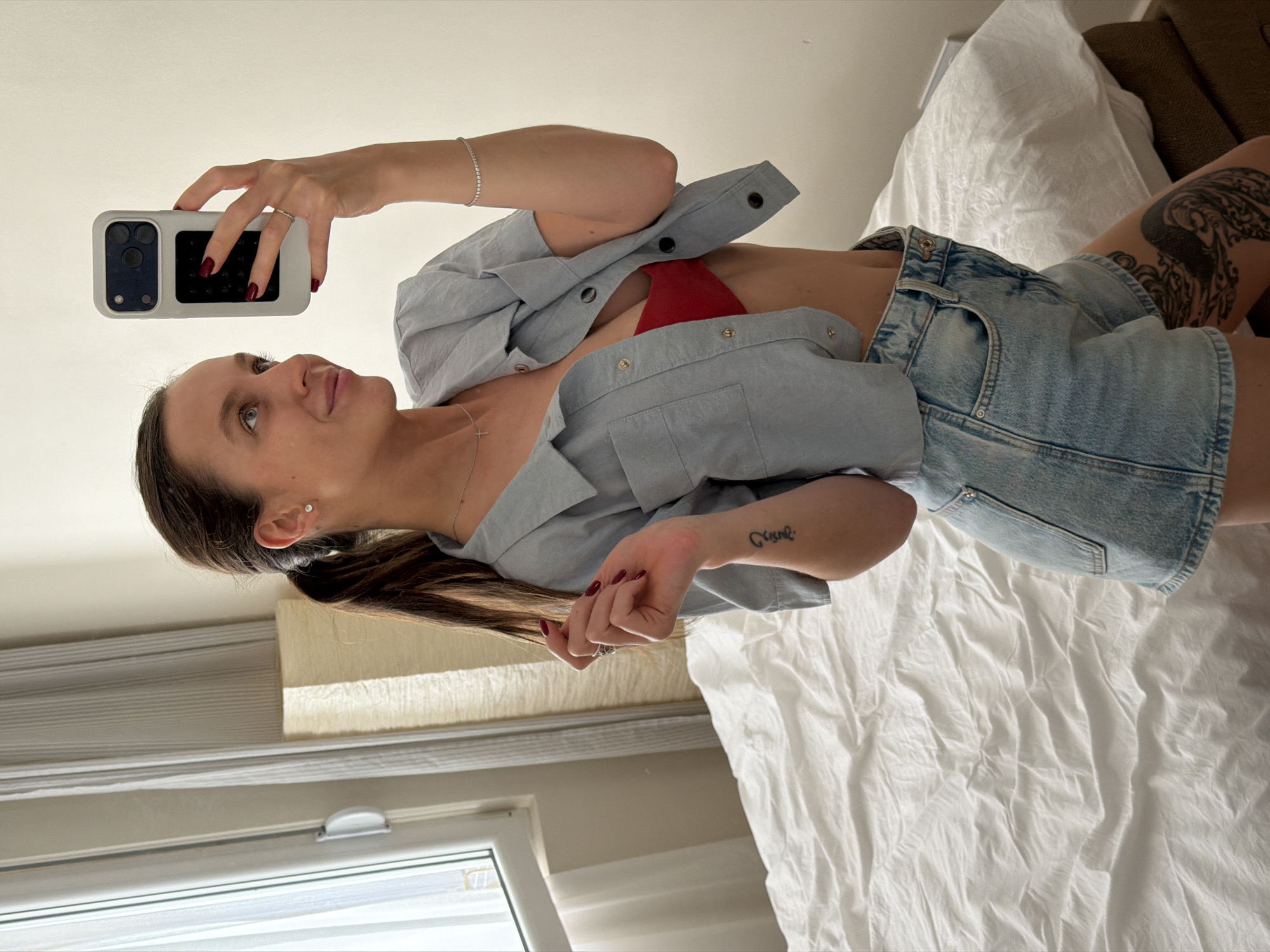 Woman takes selfies while cat relaxes in Budva apartment