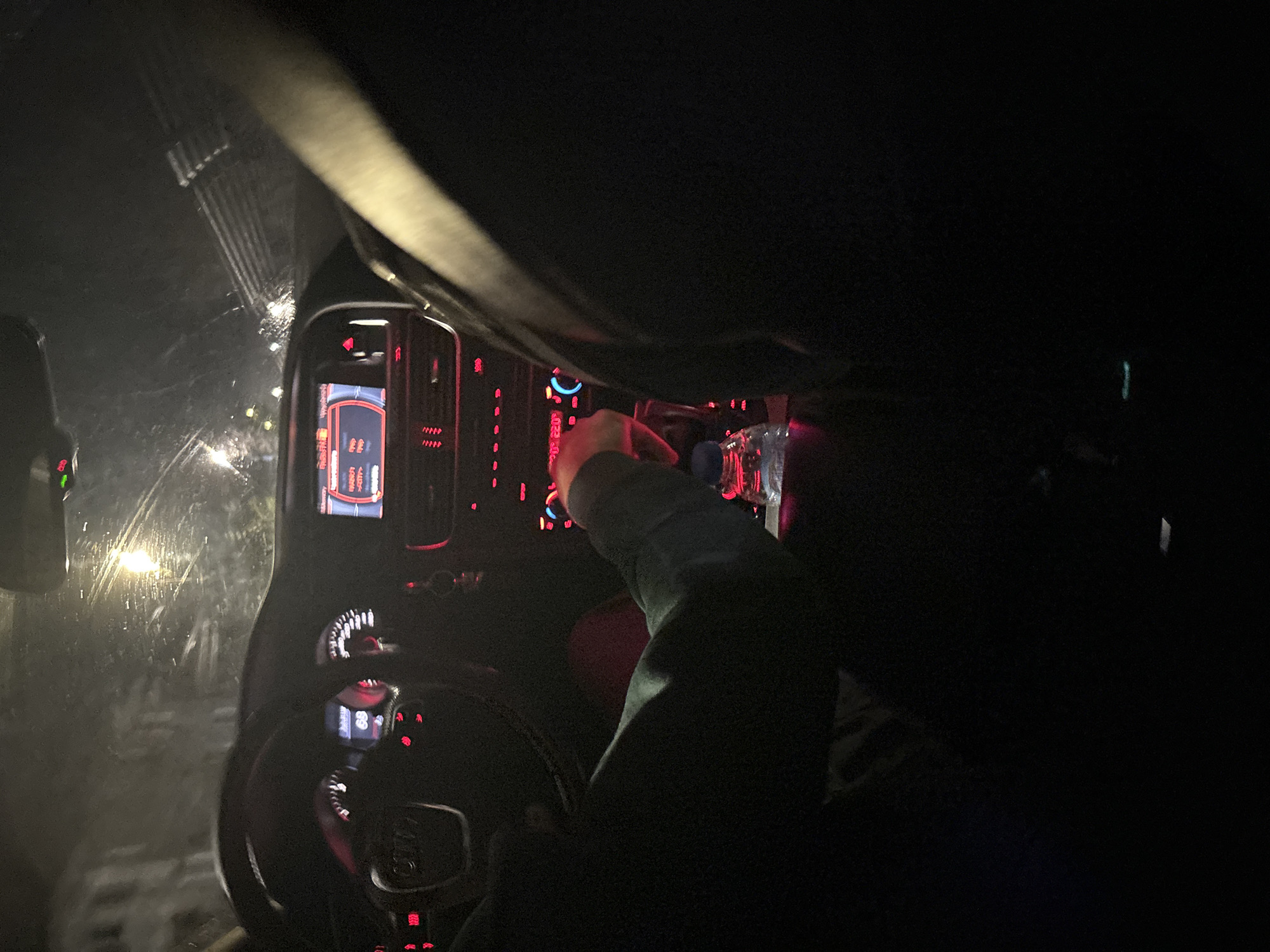 Driver adjusts console during rainy evening in Strazhitsa