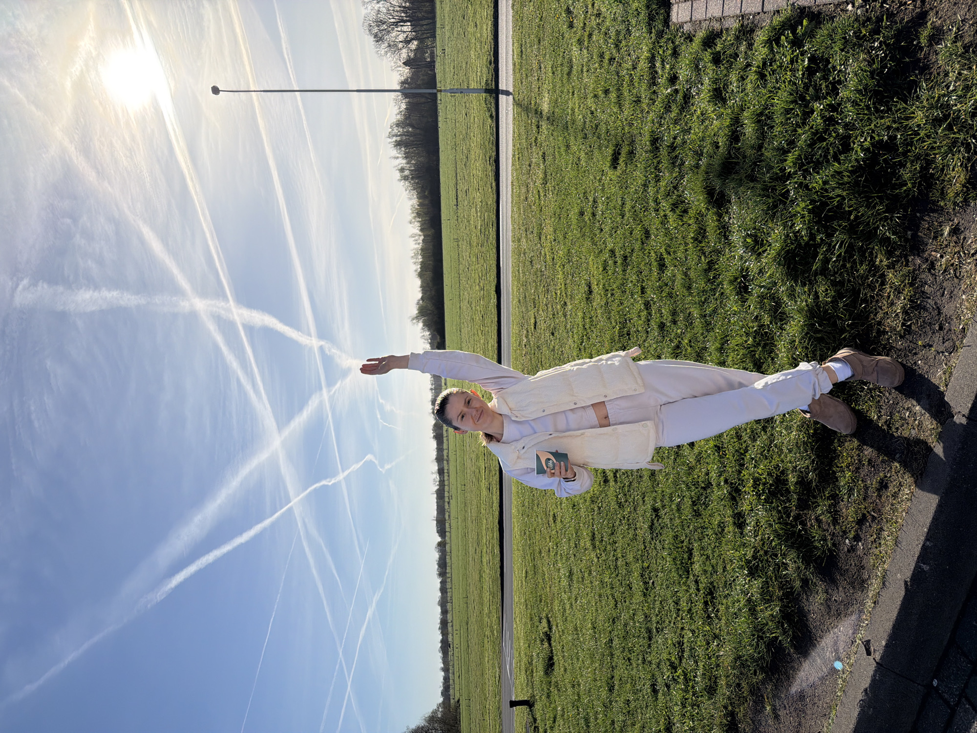Woman stands in field holding object in Klarenbeek