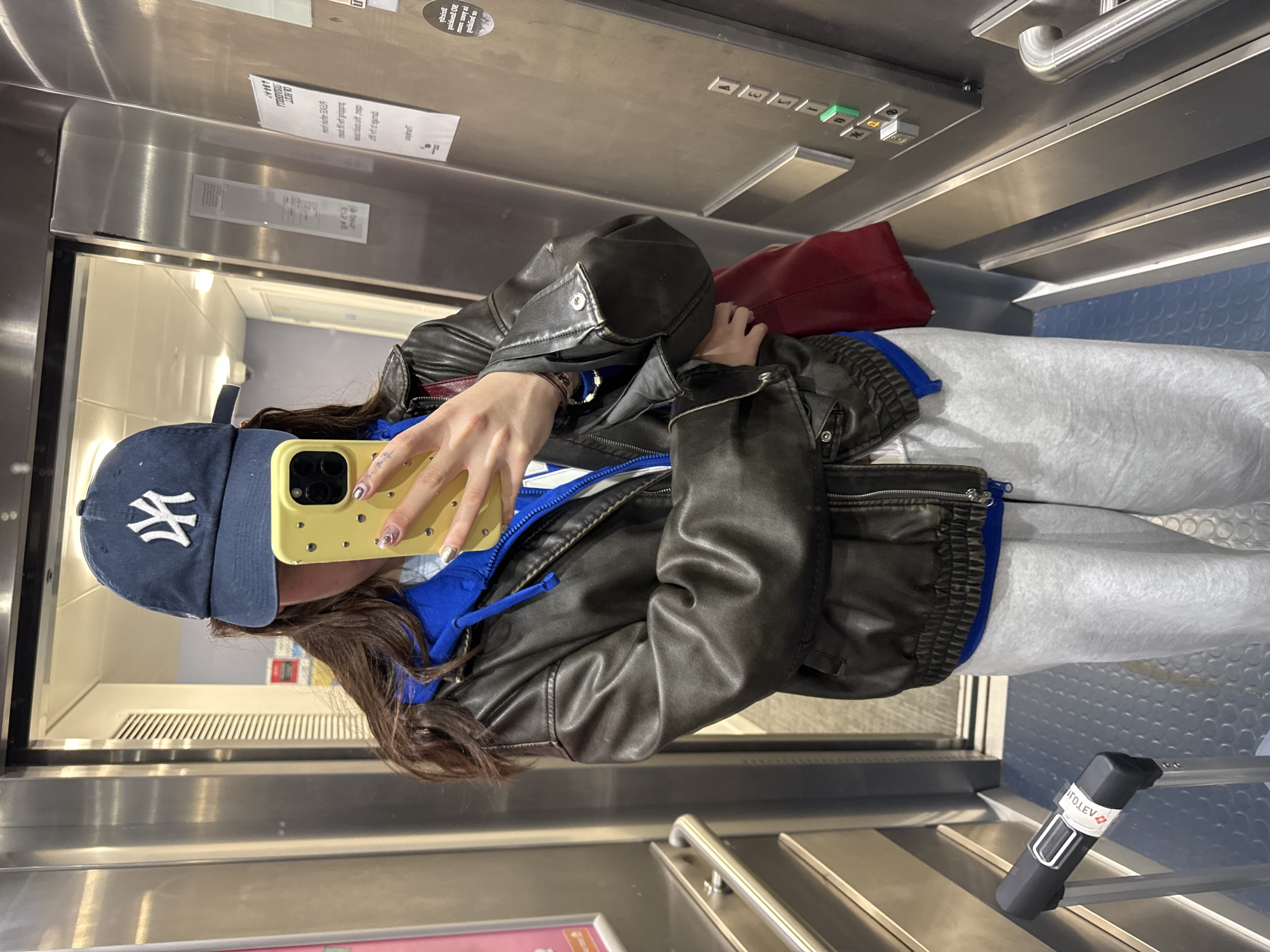 Person takes elevator selfie in Hull wearing NY cap