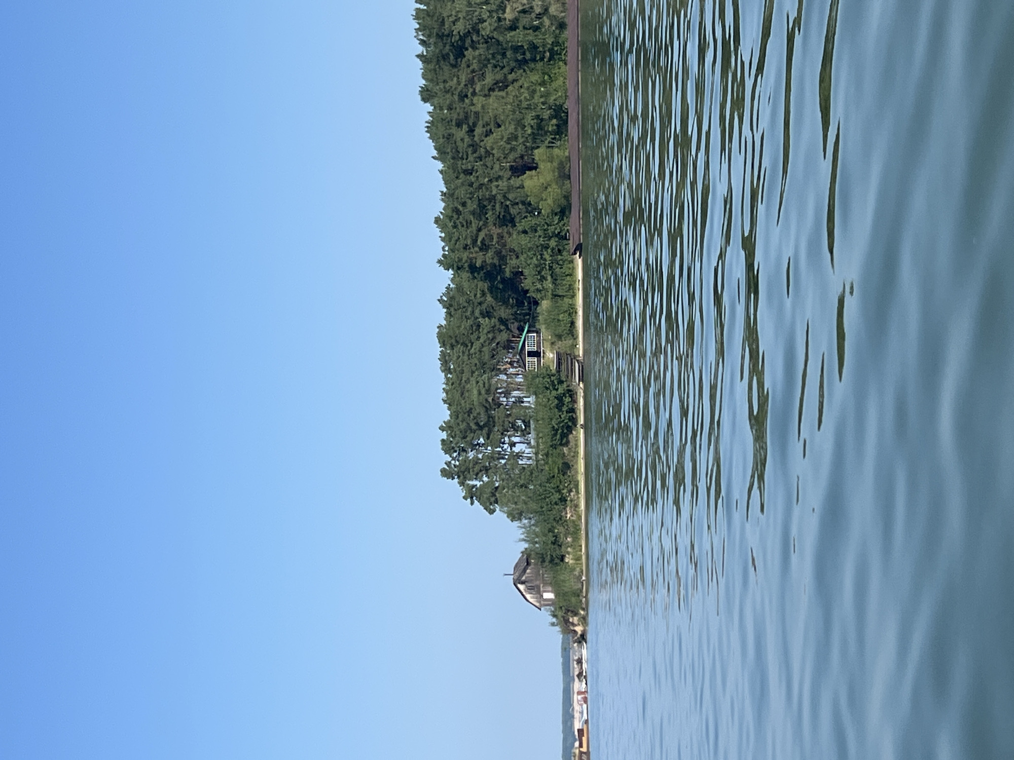 Calm Russian waterway, beached barge, and a motorboat out on the water