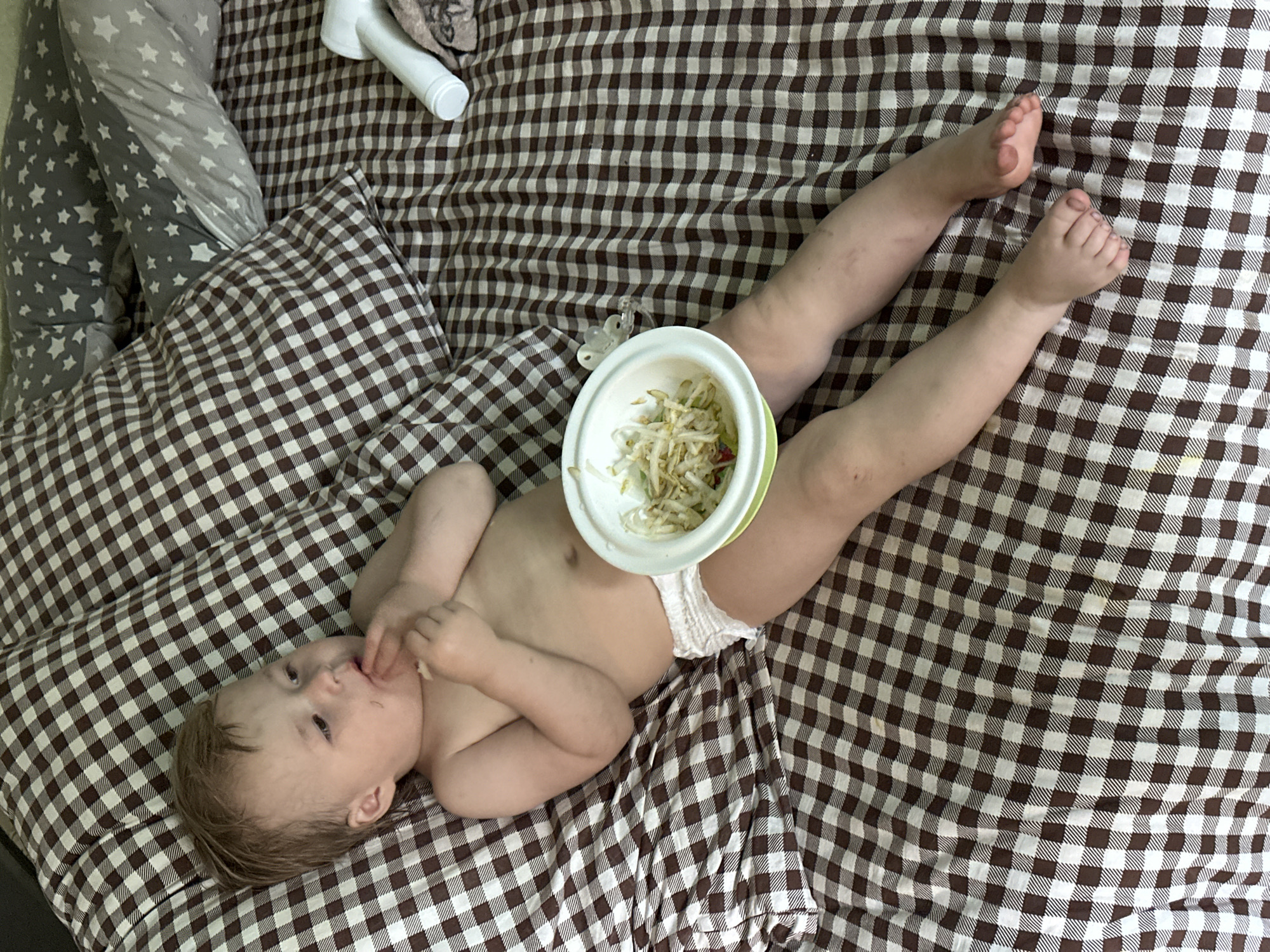 Baby feeds from bowl on stomach in Nizhny Novgorod