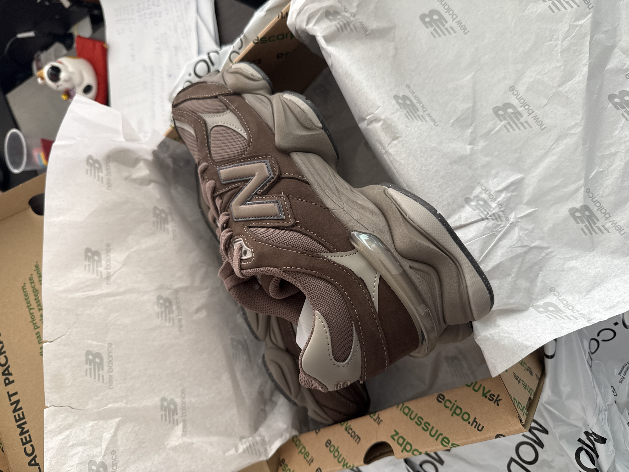 Brown New Balance 9060 sneakers documented in original packaging