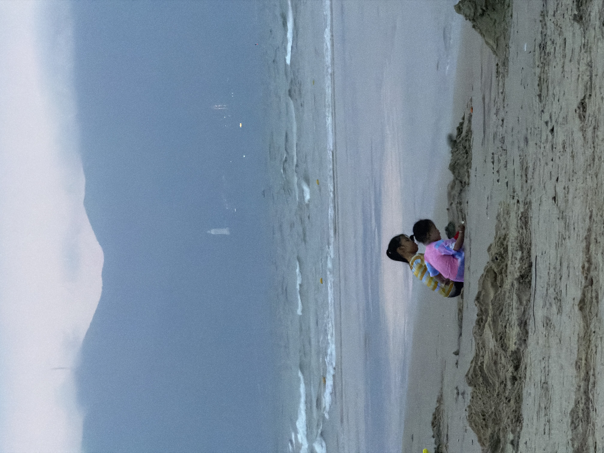 Children play on overcast Đà Nẵng beach during morning hours
