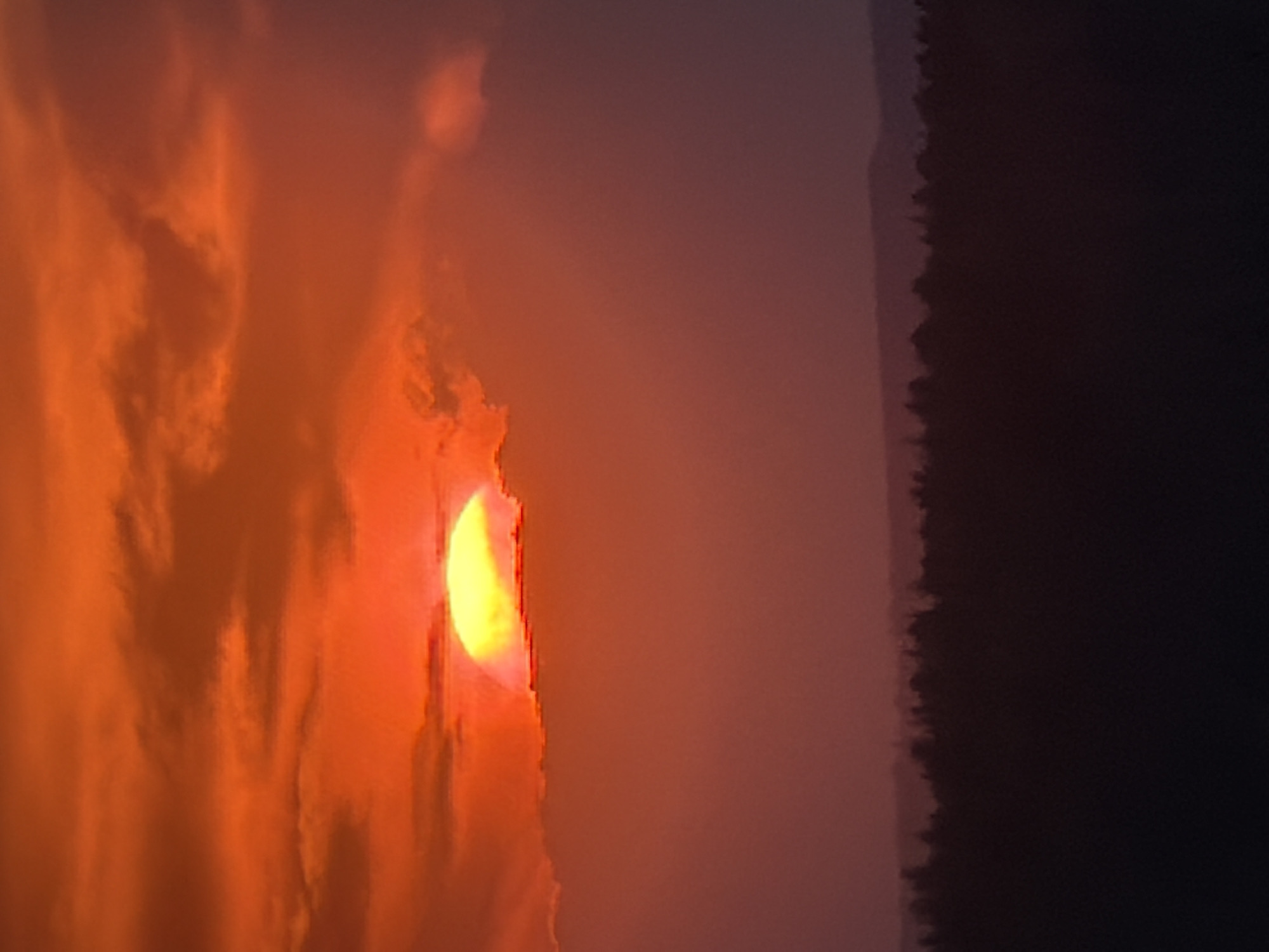 Smoky sunset observed over water near Chaikovsky, Russia