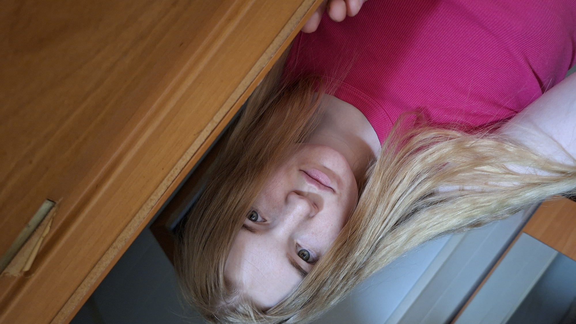 Young woman takes playful selfies indoors in rural Russia