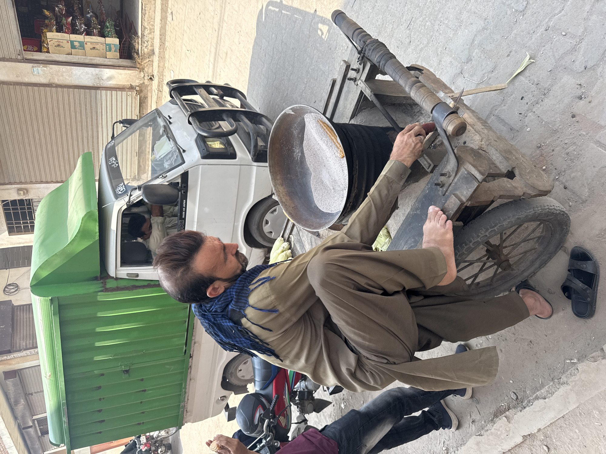 Street vendor roasts corn in sand-filled bowl in Multan
