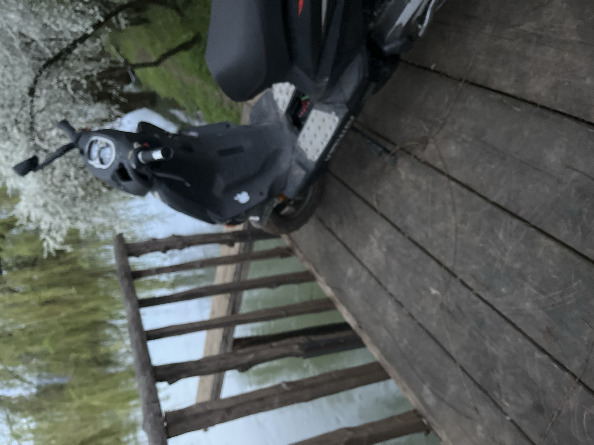 Scooter parked on wooden bridge over water in Slovenia