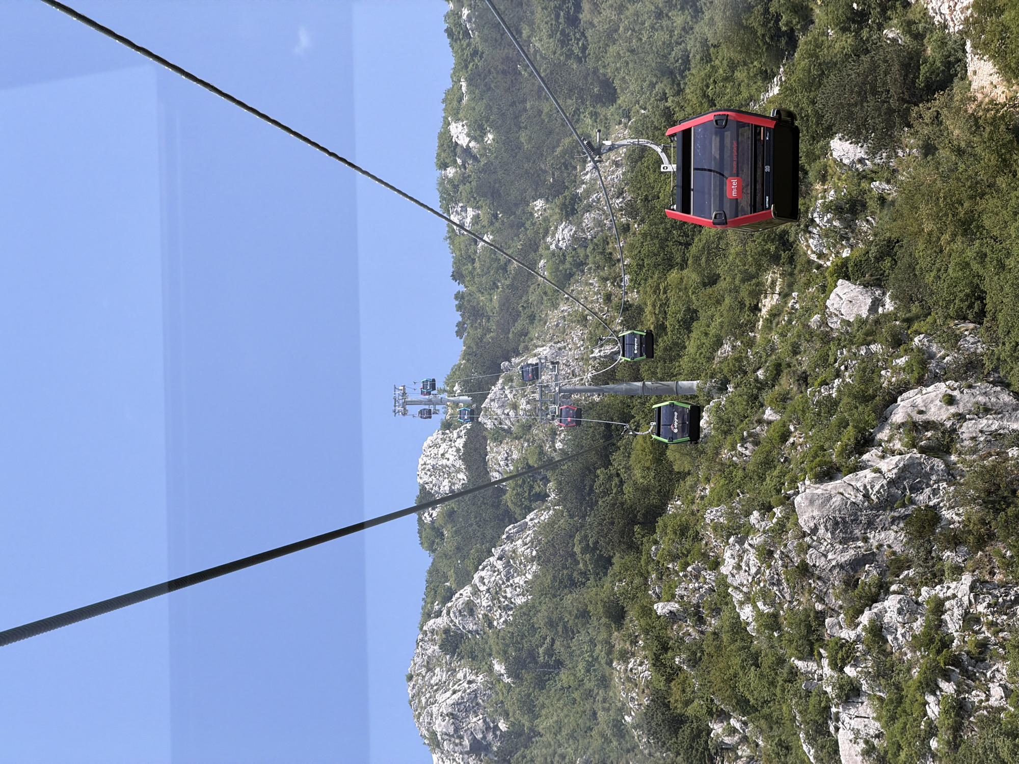 Cable car ascending lush rocky slopes in Montenegro