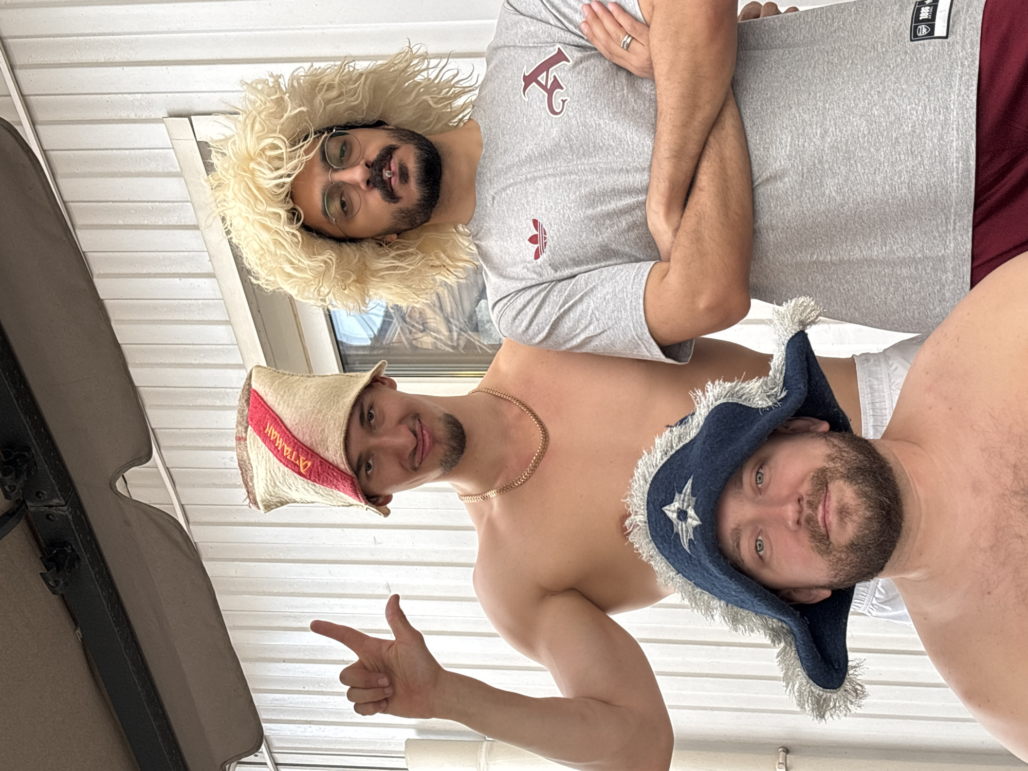 Men pose in distinctive hats during casual photo session