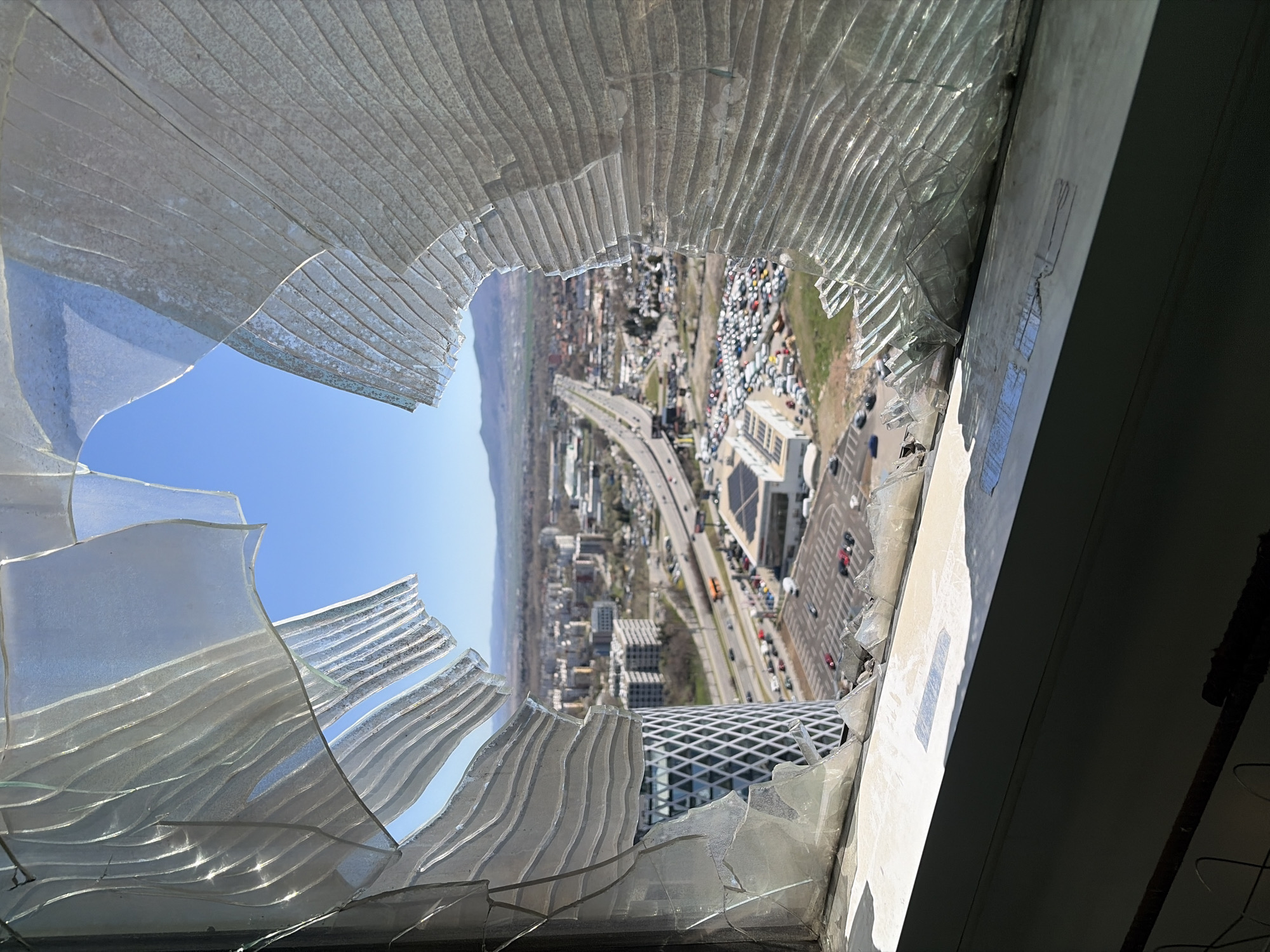 Broken high-rise window frames Sofia cityscape view