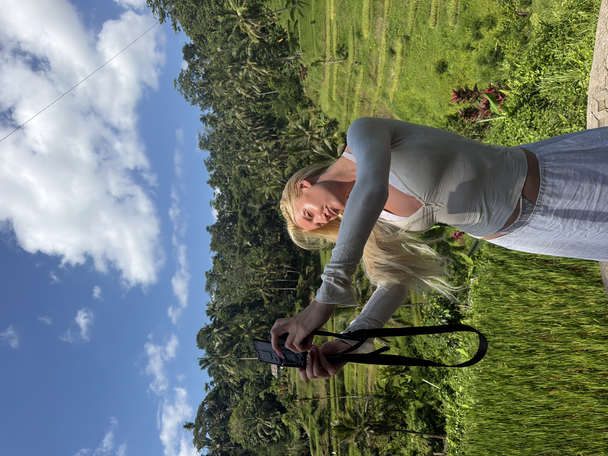 Tourists photograph, zip-line through Tegallalang rice terraces in Indonesia