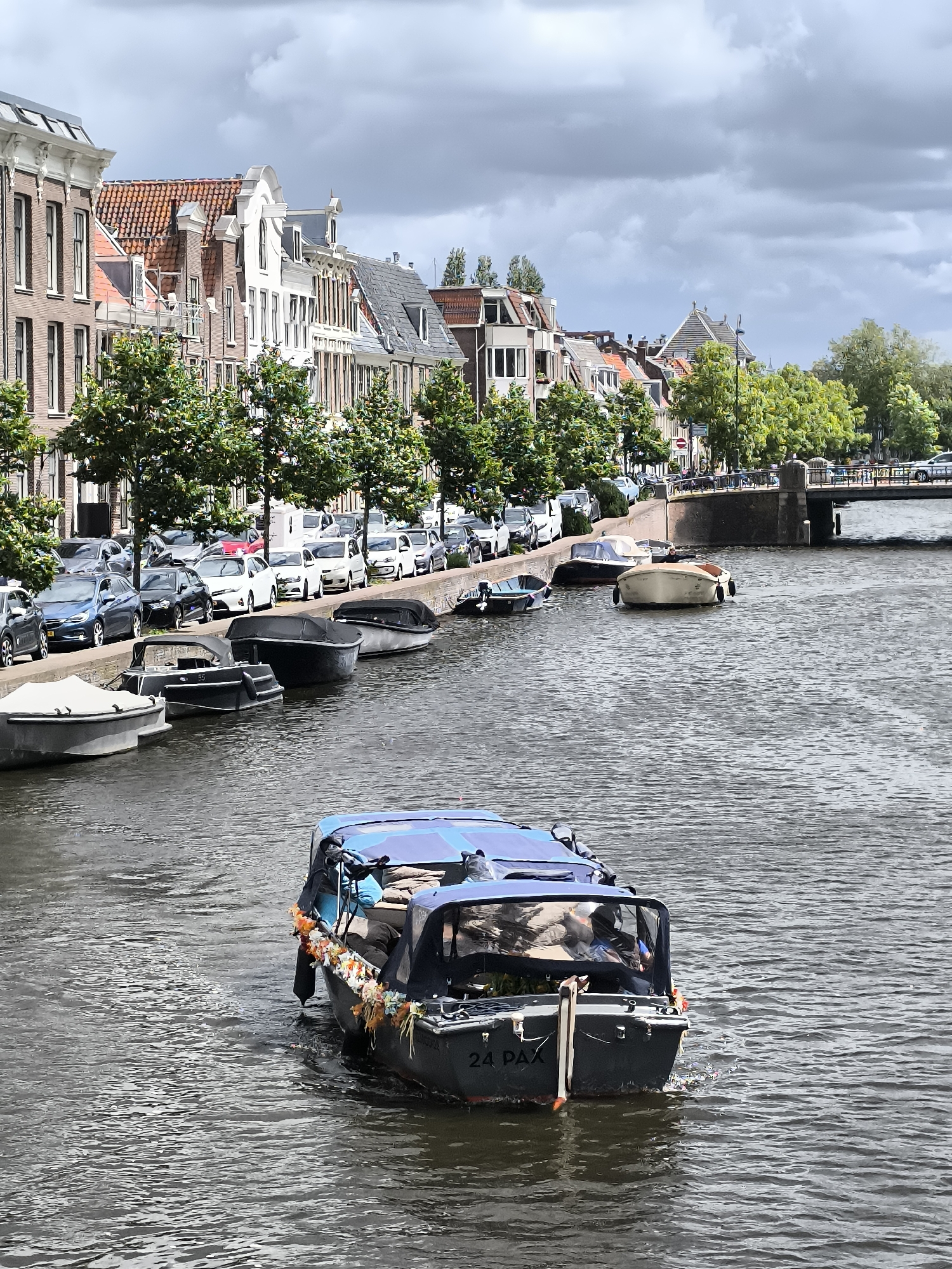 Boat travels through Haarlem canal past historic insurance building