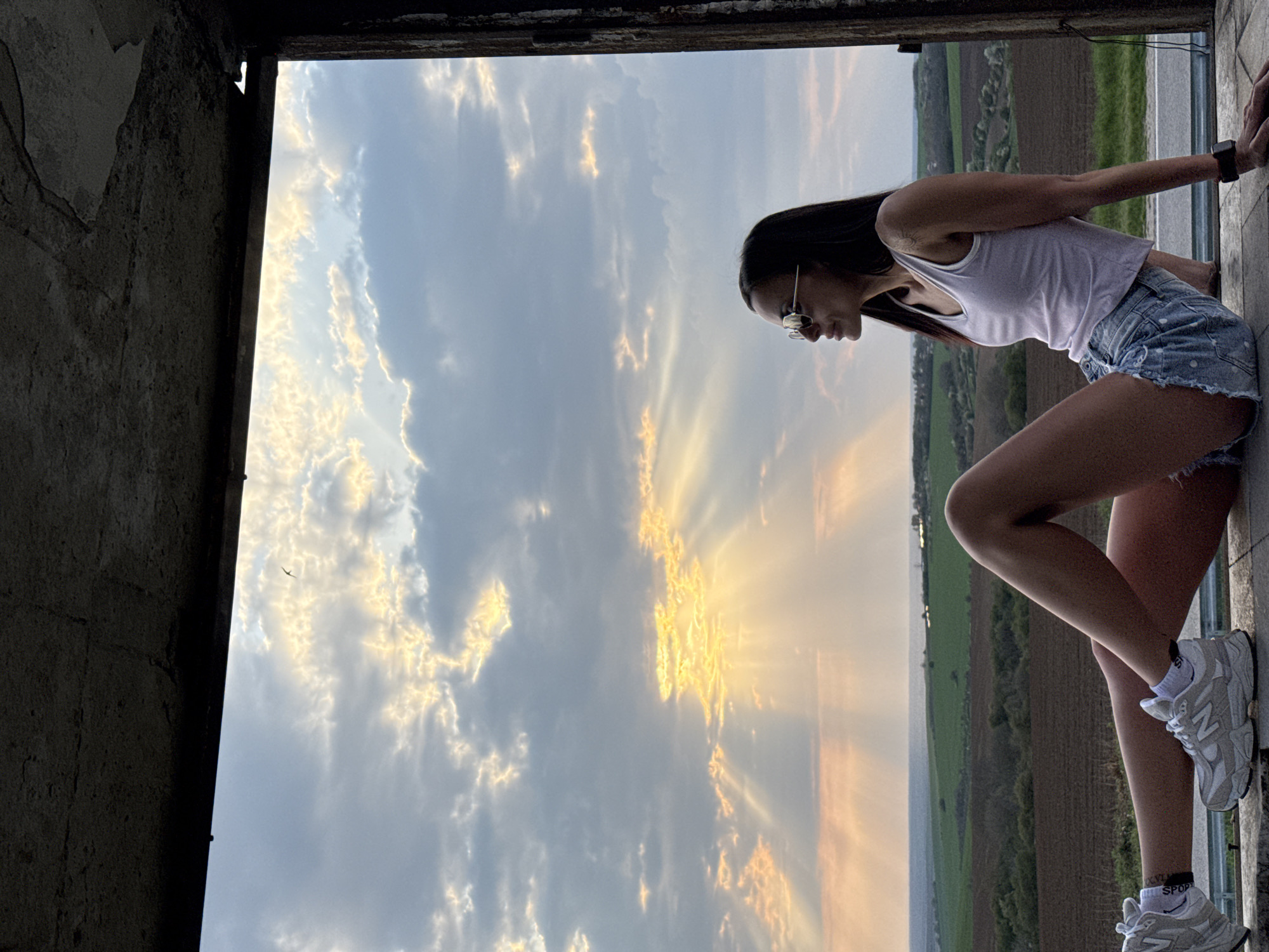 Woman poses in window during dramatic sunset in Pleven