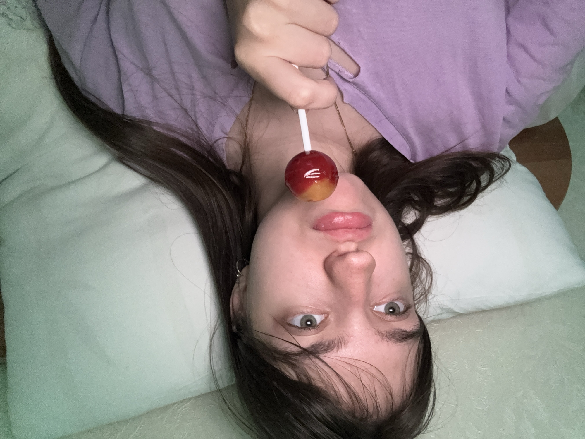 Woman spends morning in bed with lollipop and kitten