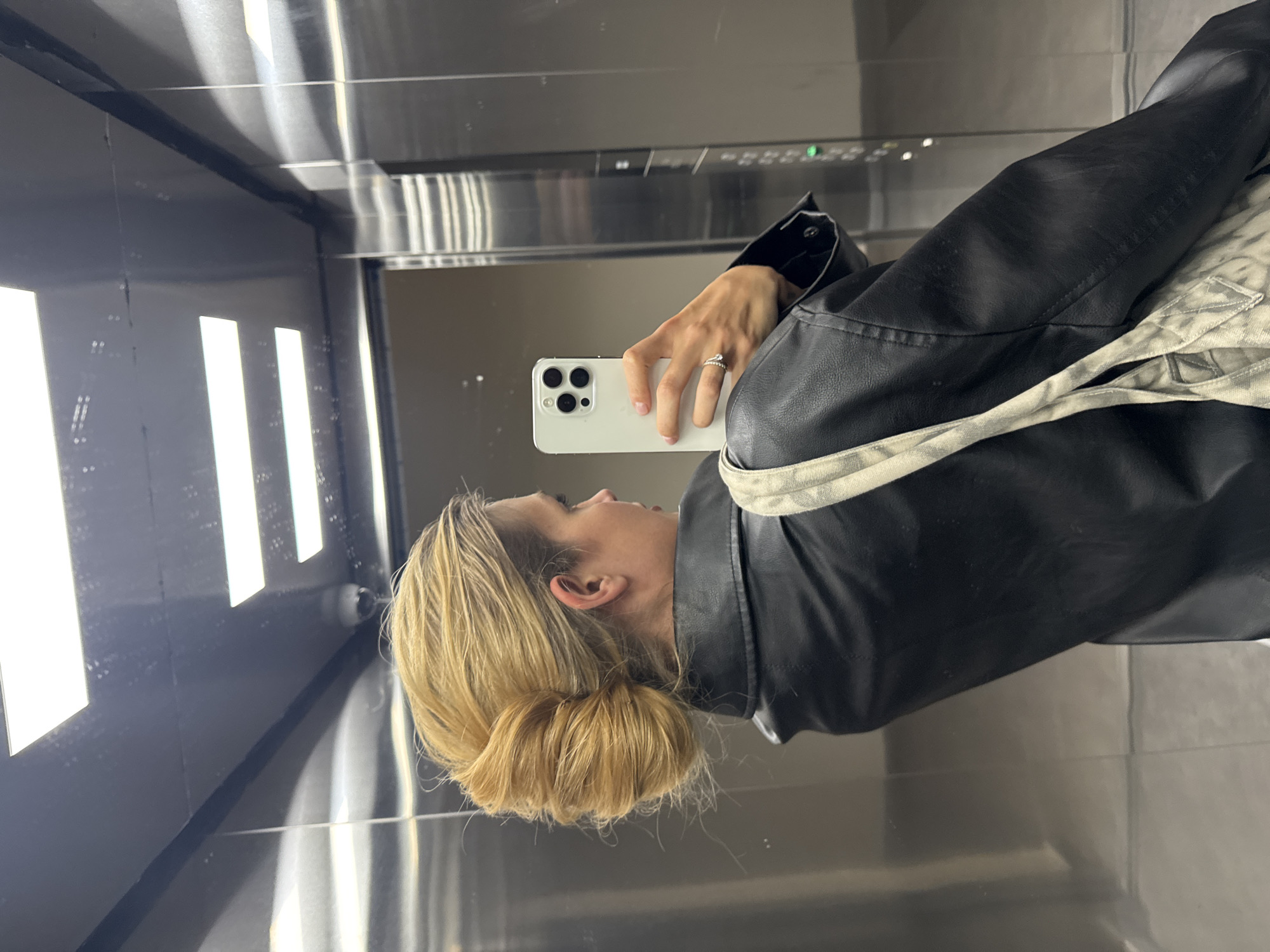 Woman Takes Elevator Selfies in Black Leather Jacket