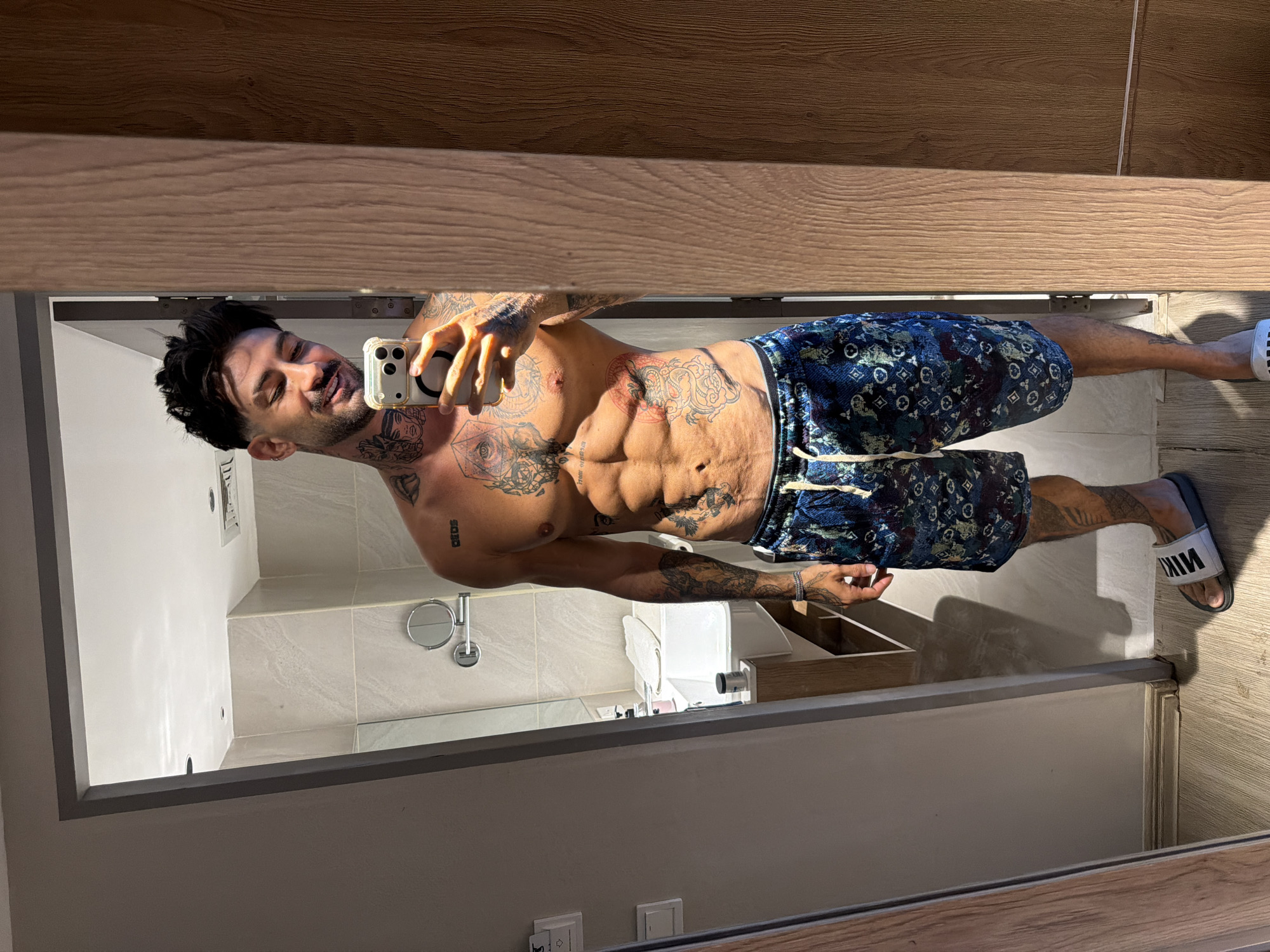 Tattooed man takes mirror selfie in Patong, Thailand