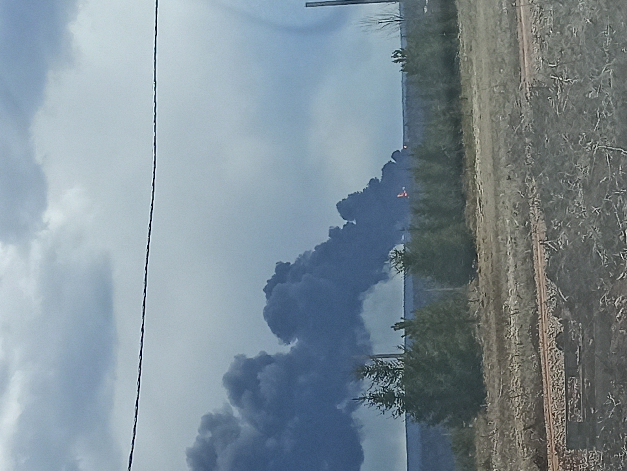 Dark smoke plume observed over rural landscape Wednesday morning