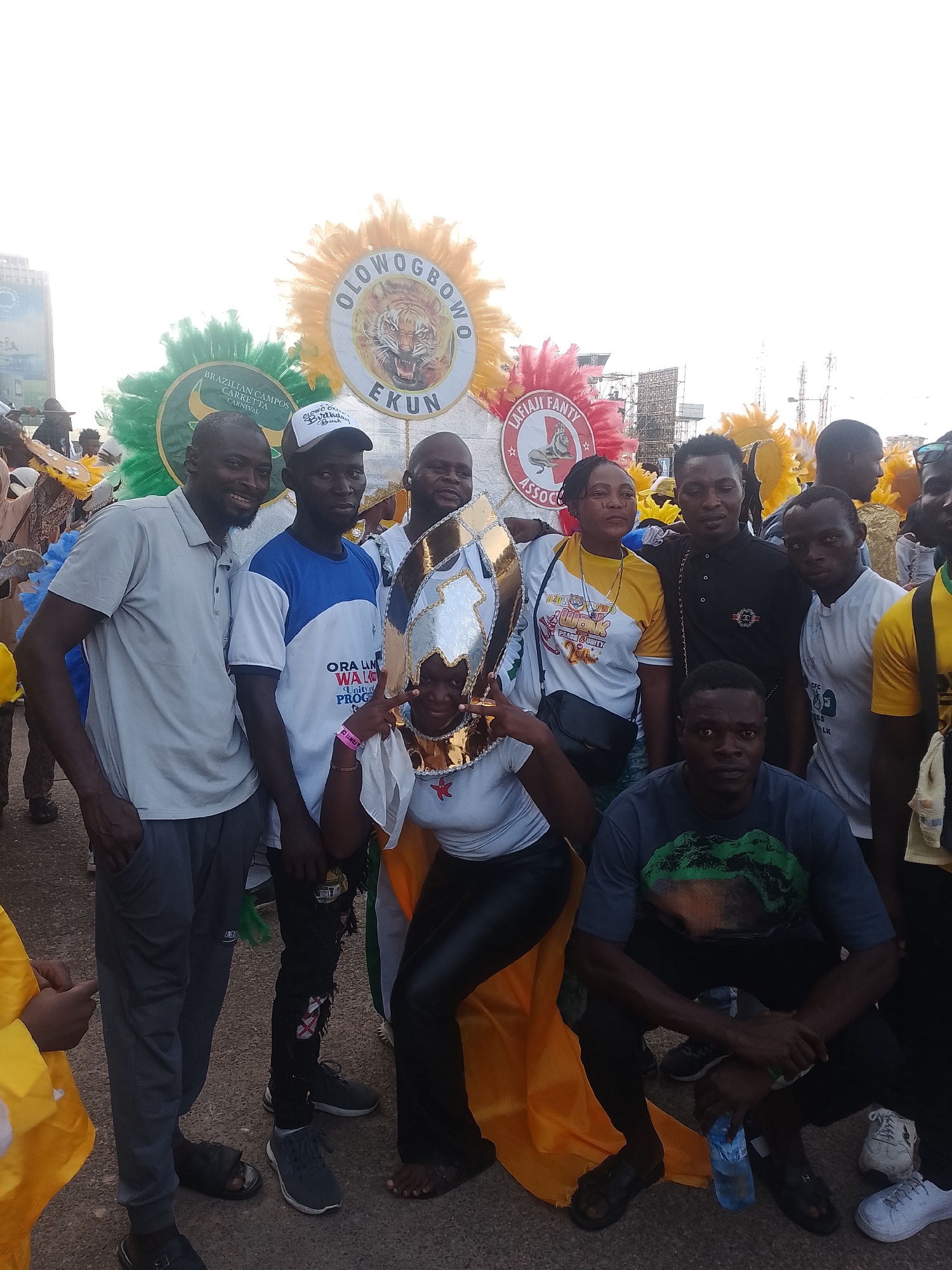 Group gathers with carnival emblems at outdoor location