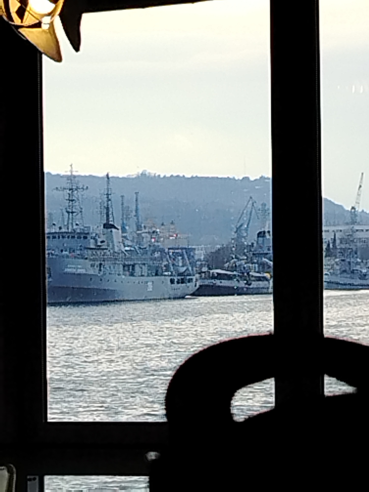Harbor with naval vessels viewed through window in Varna