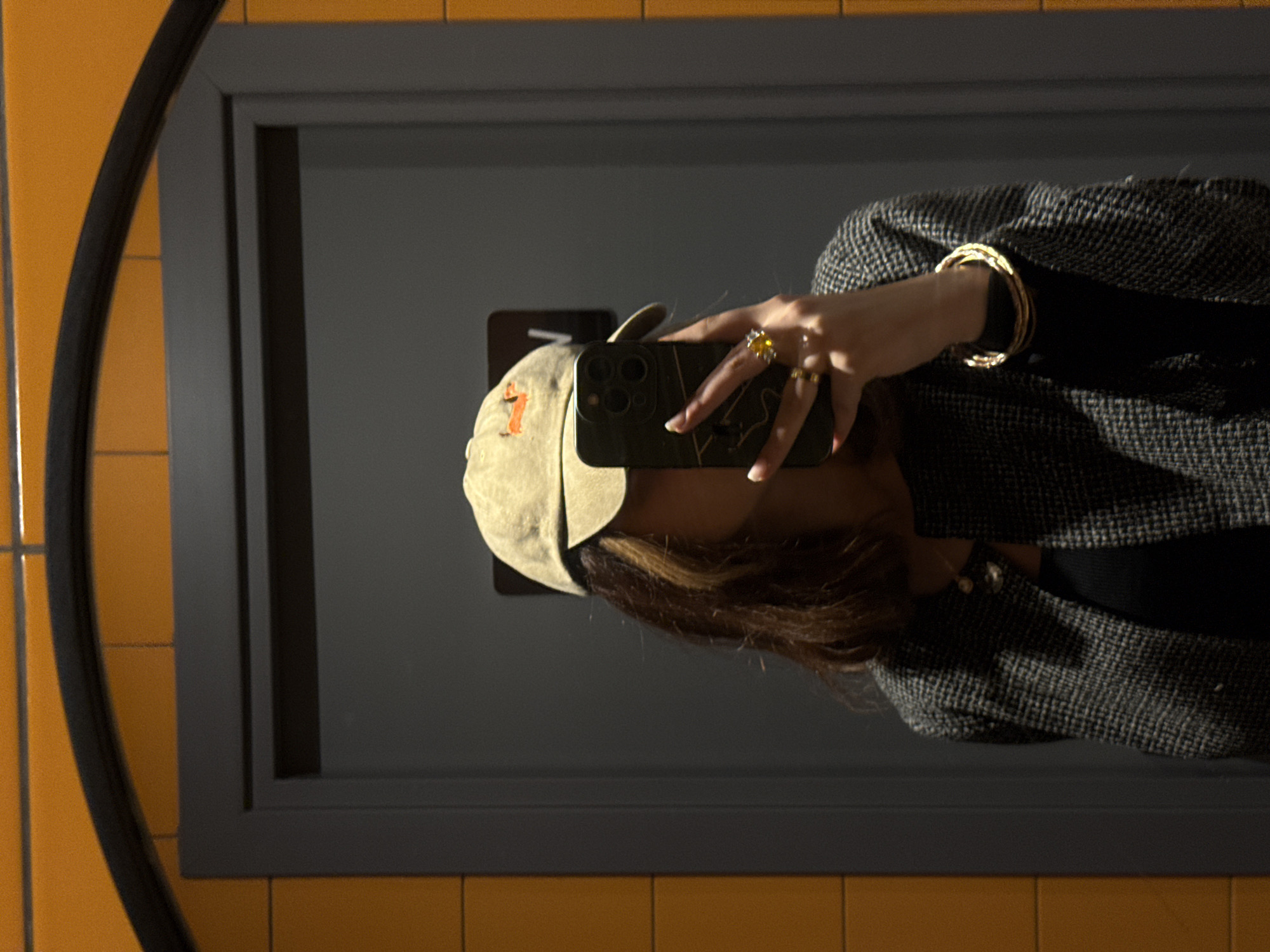 Person takes mirror selfie in Yerevan wearing hat and jewelry
