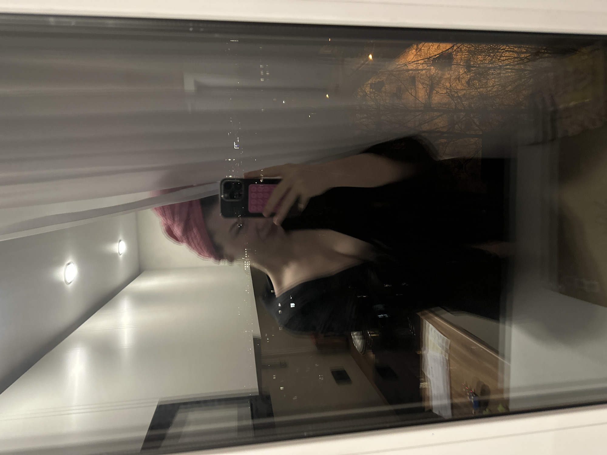 Woman takes selfie, drinks pink beverage in Kazan evening