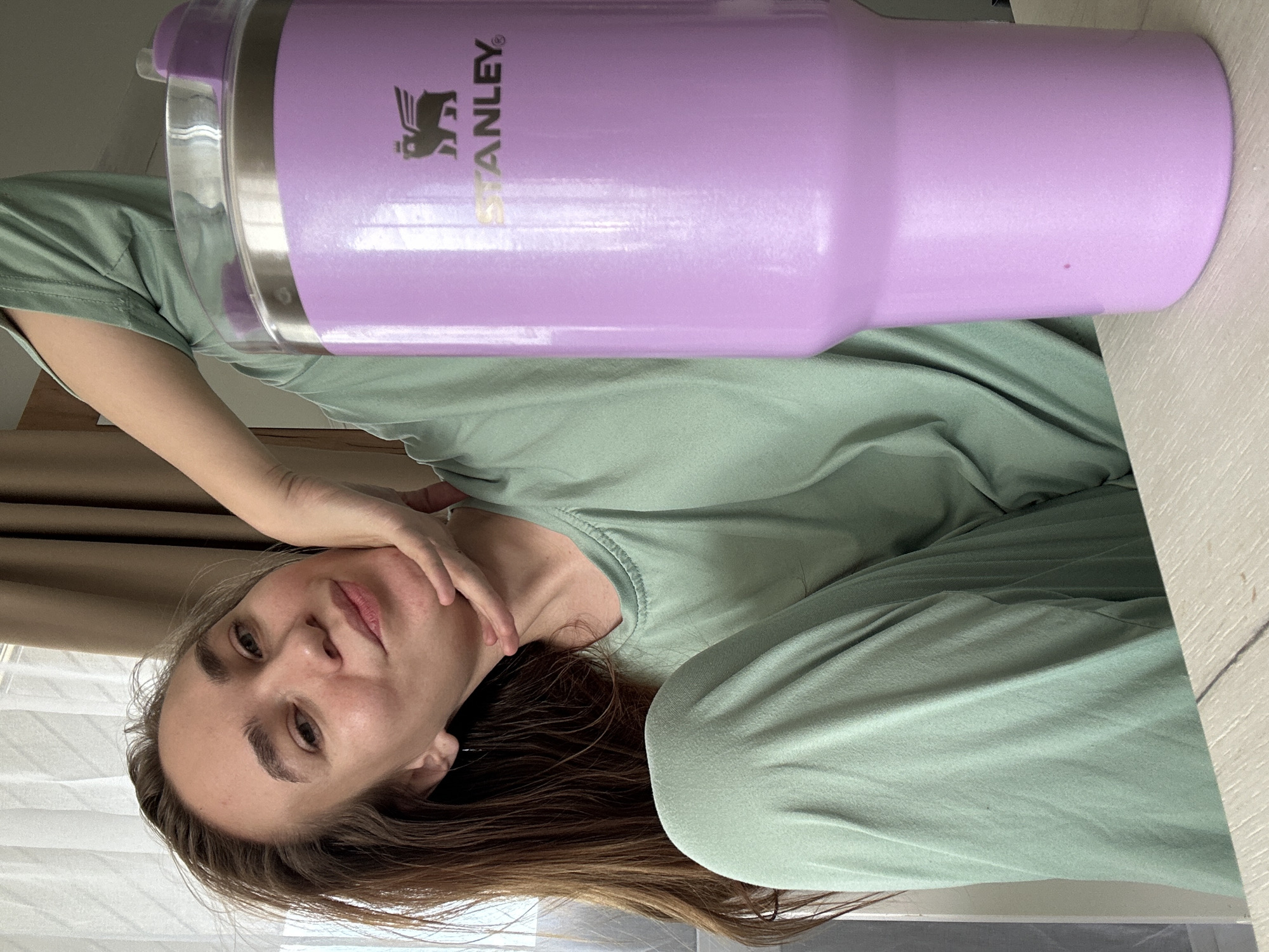 Woman drinks from purple Stanley tumbler in Kharnavy, Russia