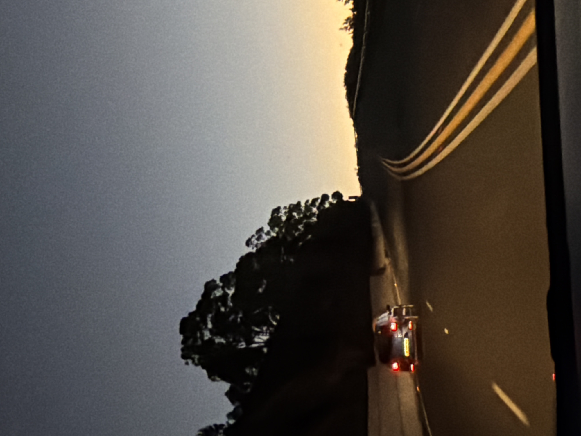 Car travels scenic Sir Lowry's Pass at twilight