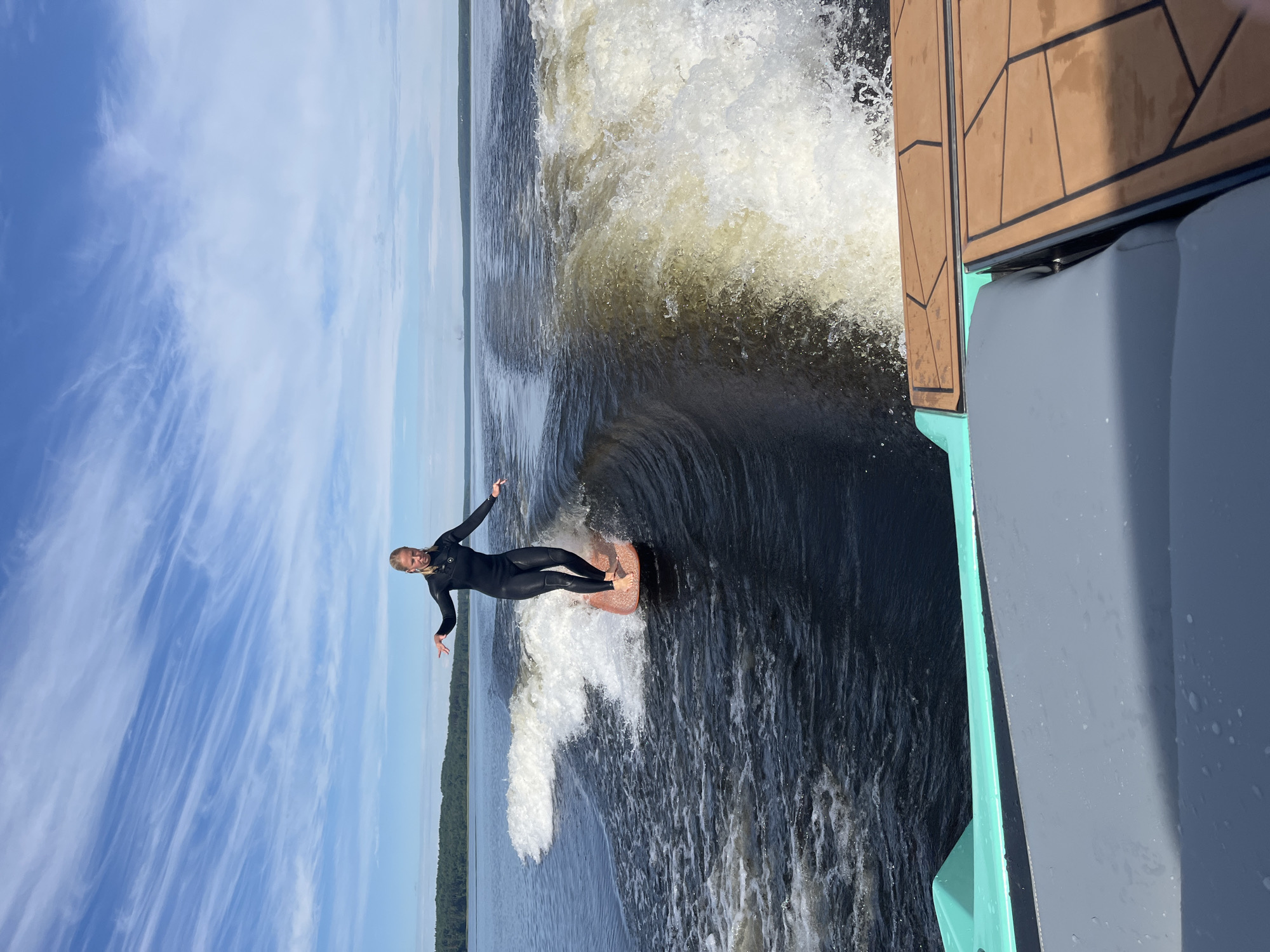 Wake surfing behind a boat on a Russian lake