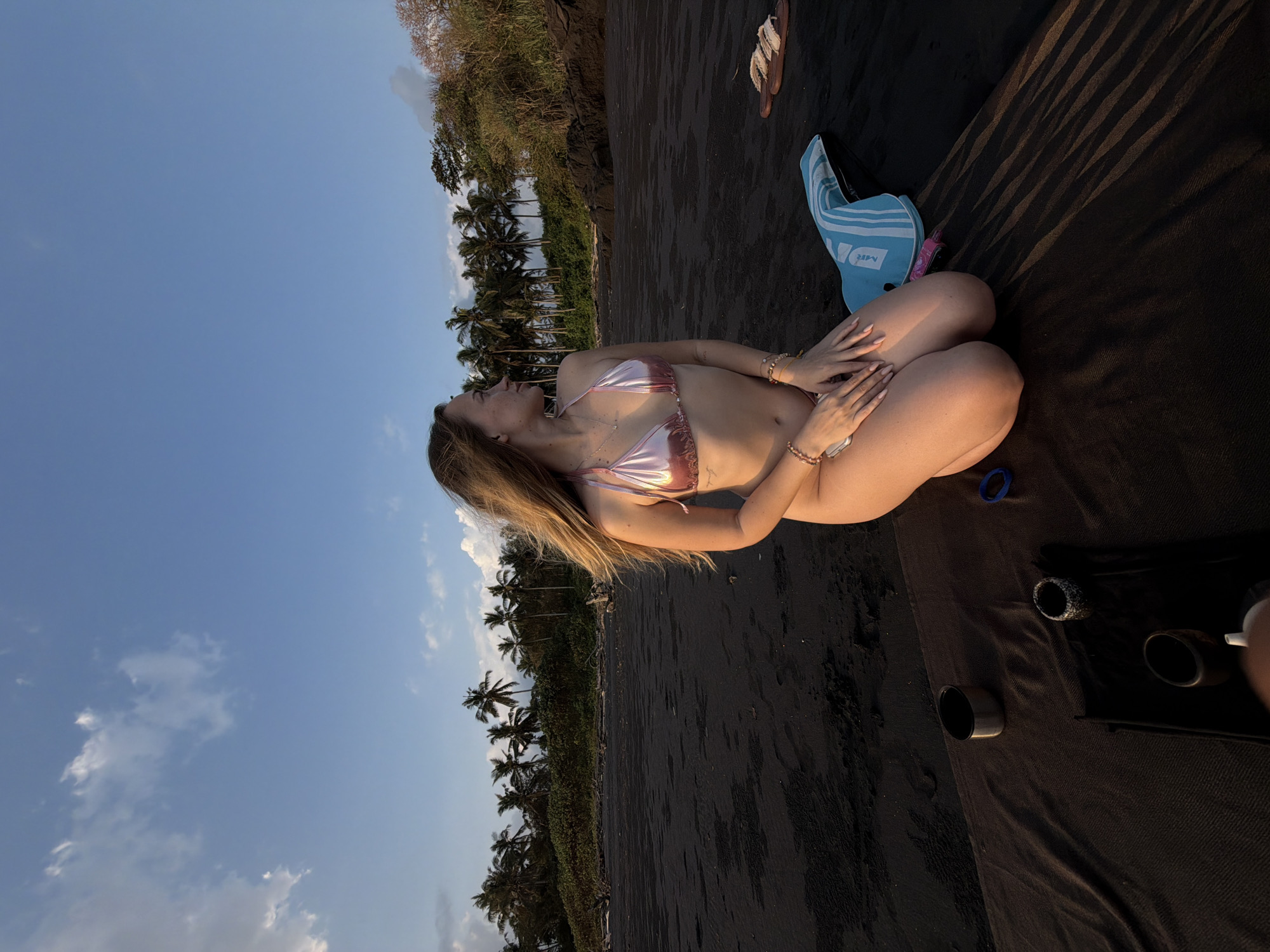 Kneeling on a black sand beach in Selemadeg Timur