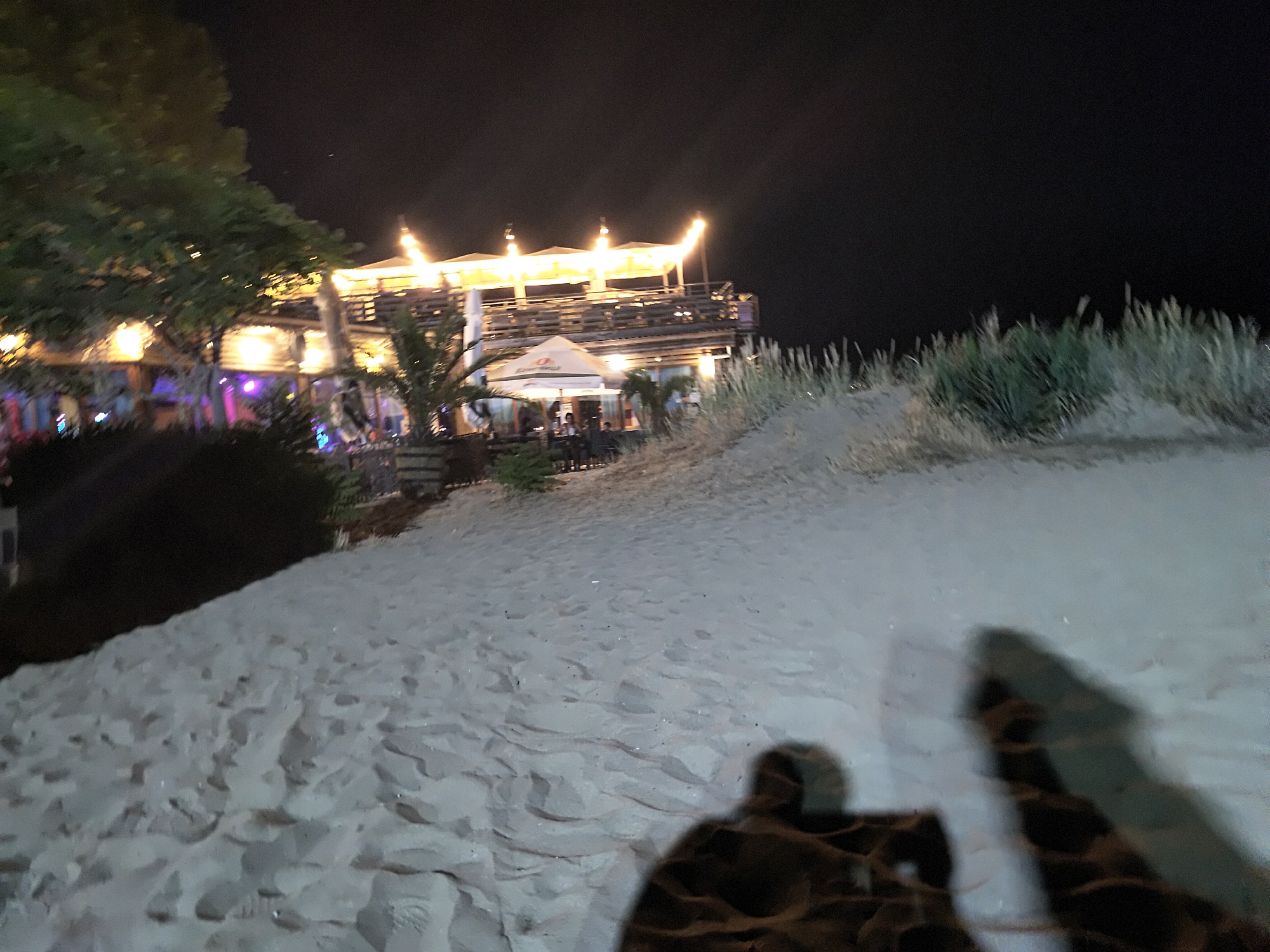Moonlit beach night out with rides, bars, and hotel nearby