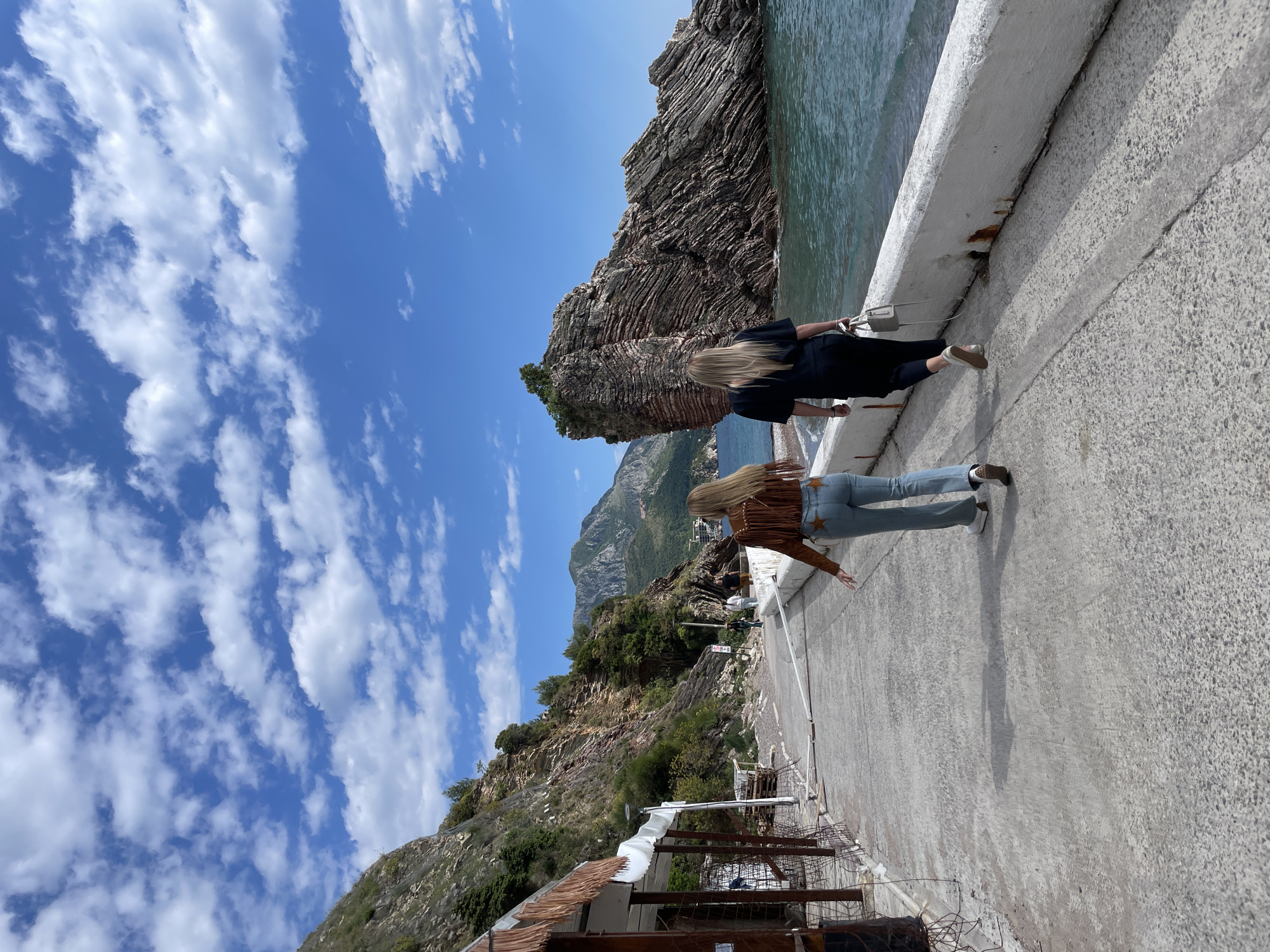 Women photograph seaside moments on Montenegro pier