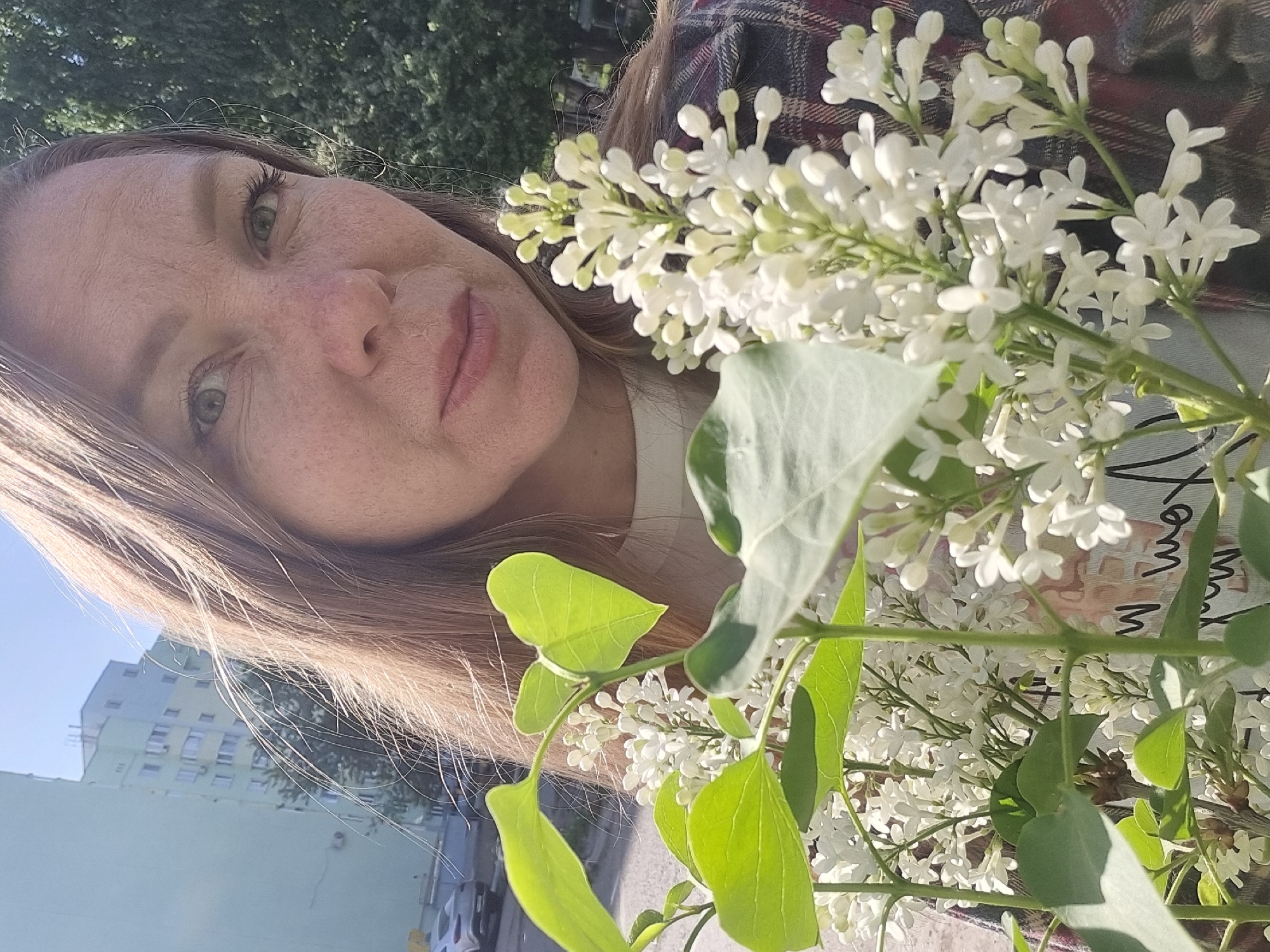 Woman poses with white lilac bouquet in Chaikovsky