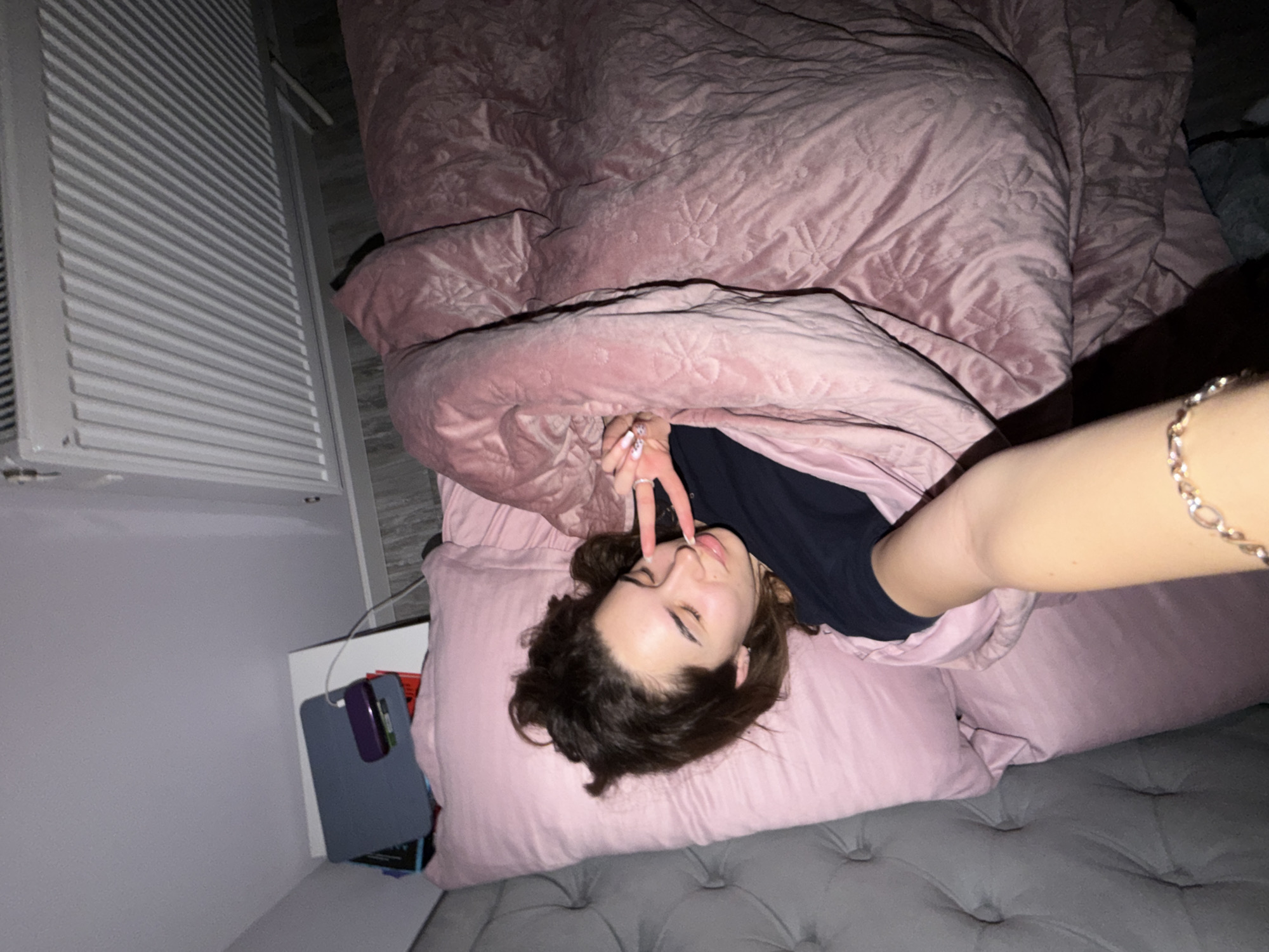 Woman relaxes in pink bedroom during evening in Dobrich