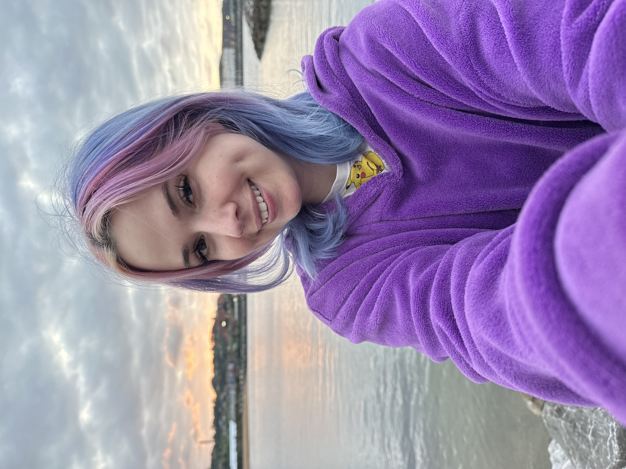 Woman takes sunset selfies at Gijón waterfront