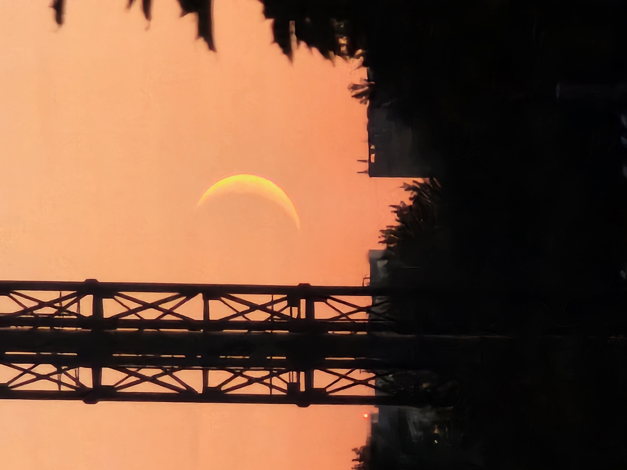 Crescent moon rises over an orange Khimki skyline