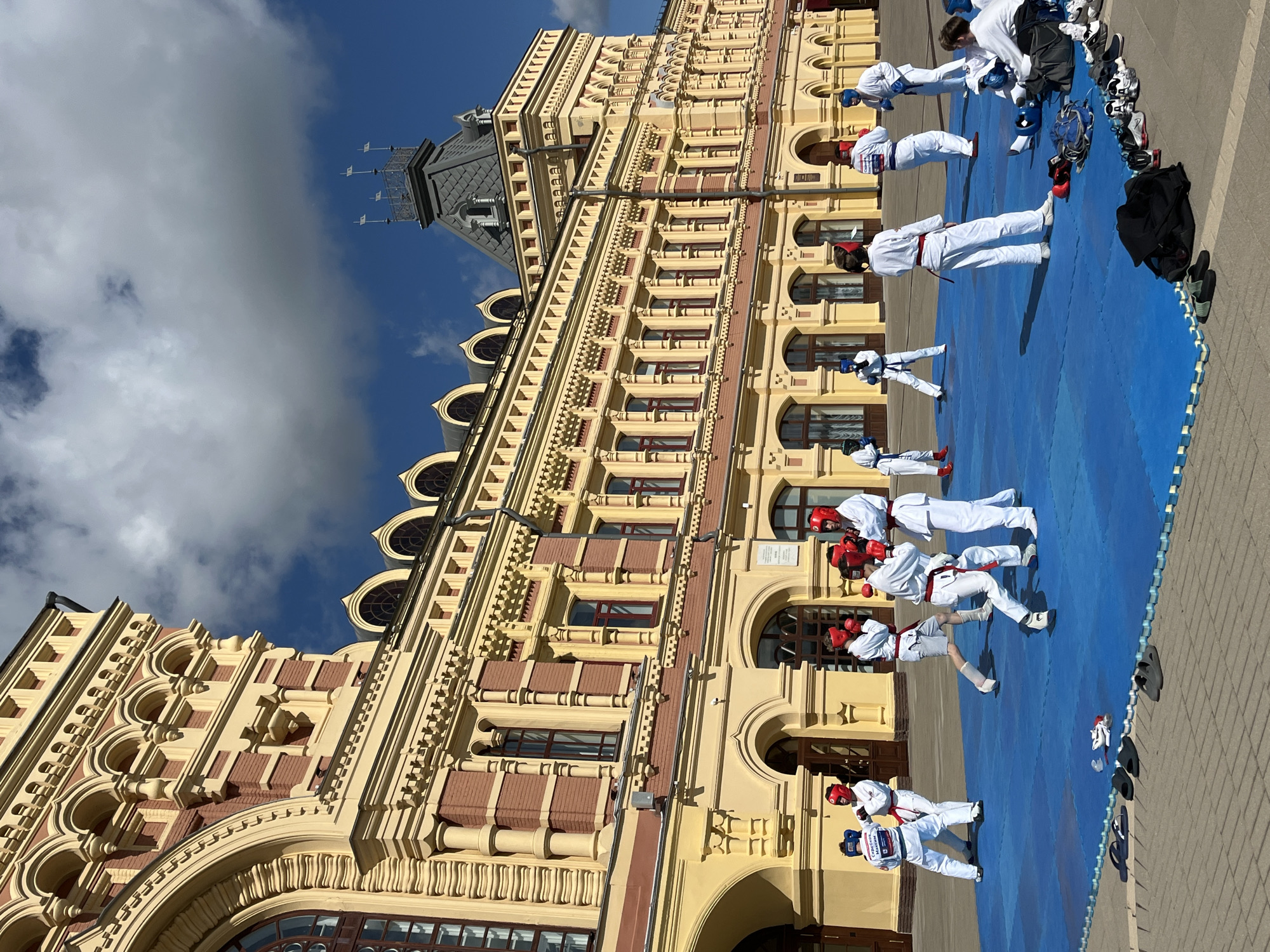 Outdoor karate session on blue mat in front of ornate Nizhny Novgorod building