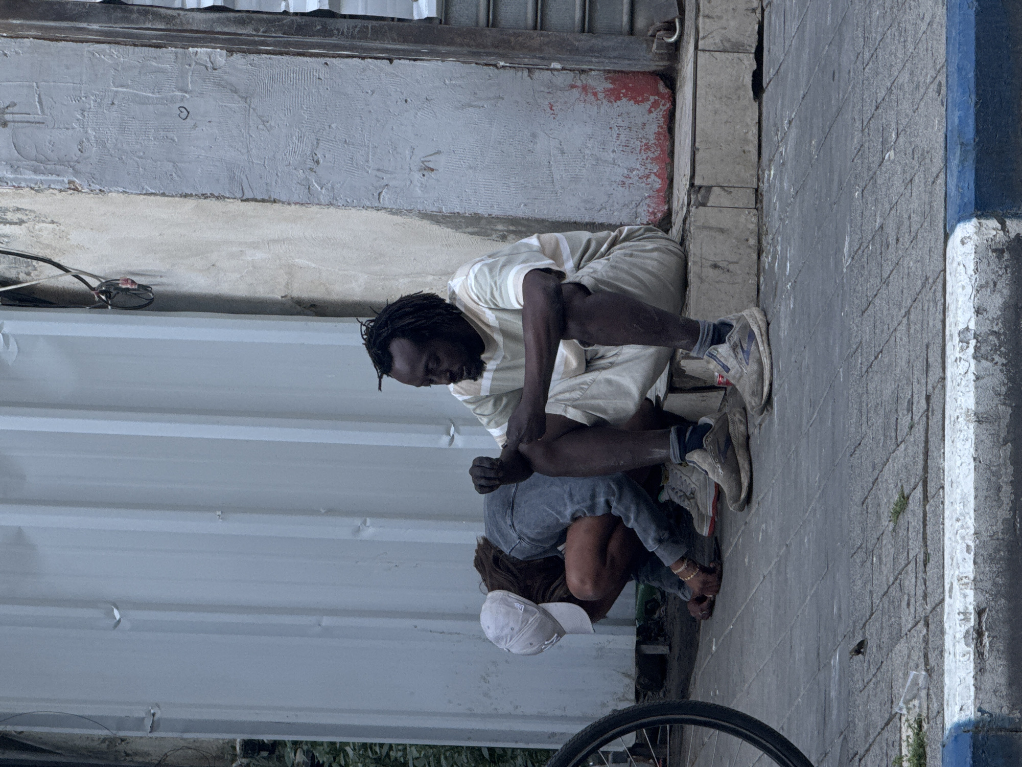 Two people crouched on Tel Aviv sidewalk early morning