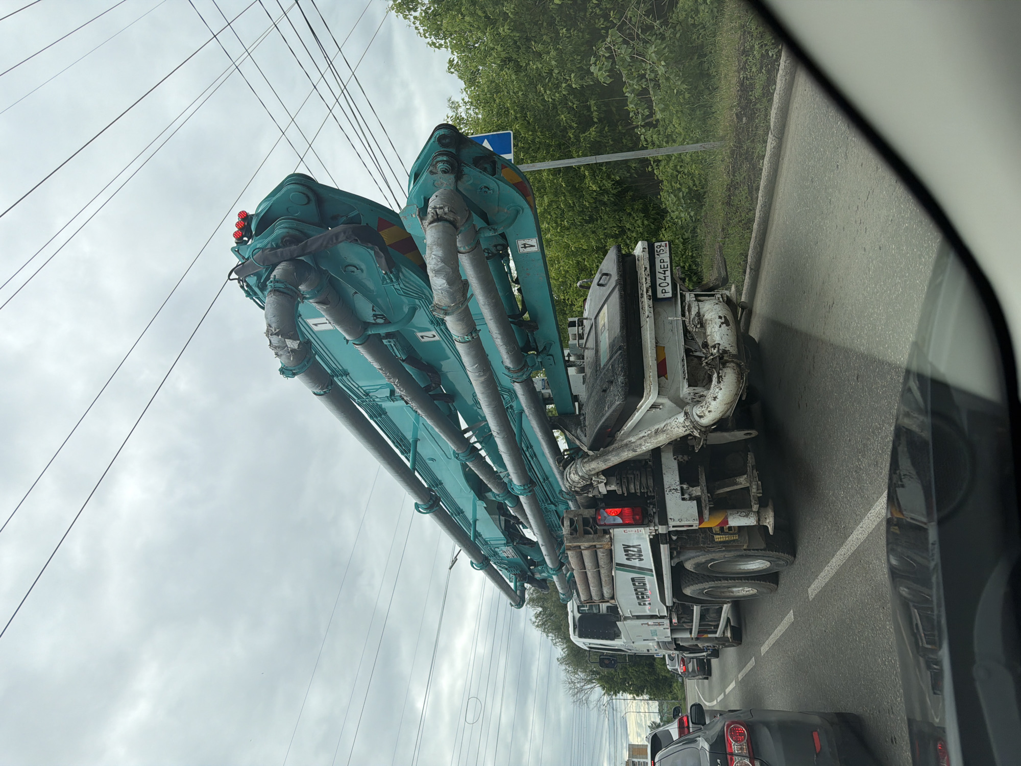 Woman takes car selfies near construction truck in Chaikovsky