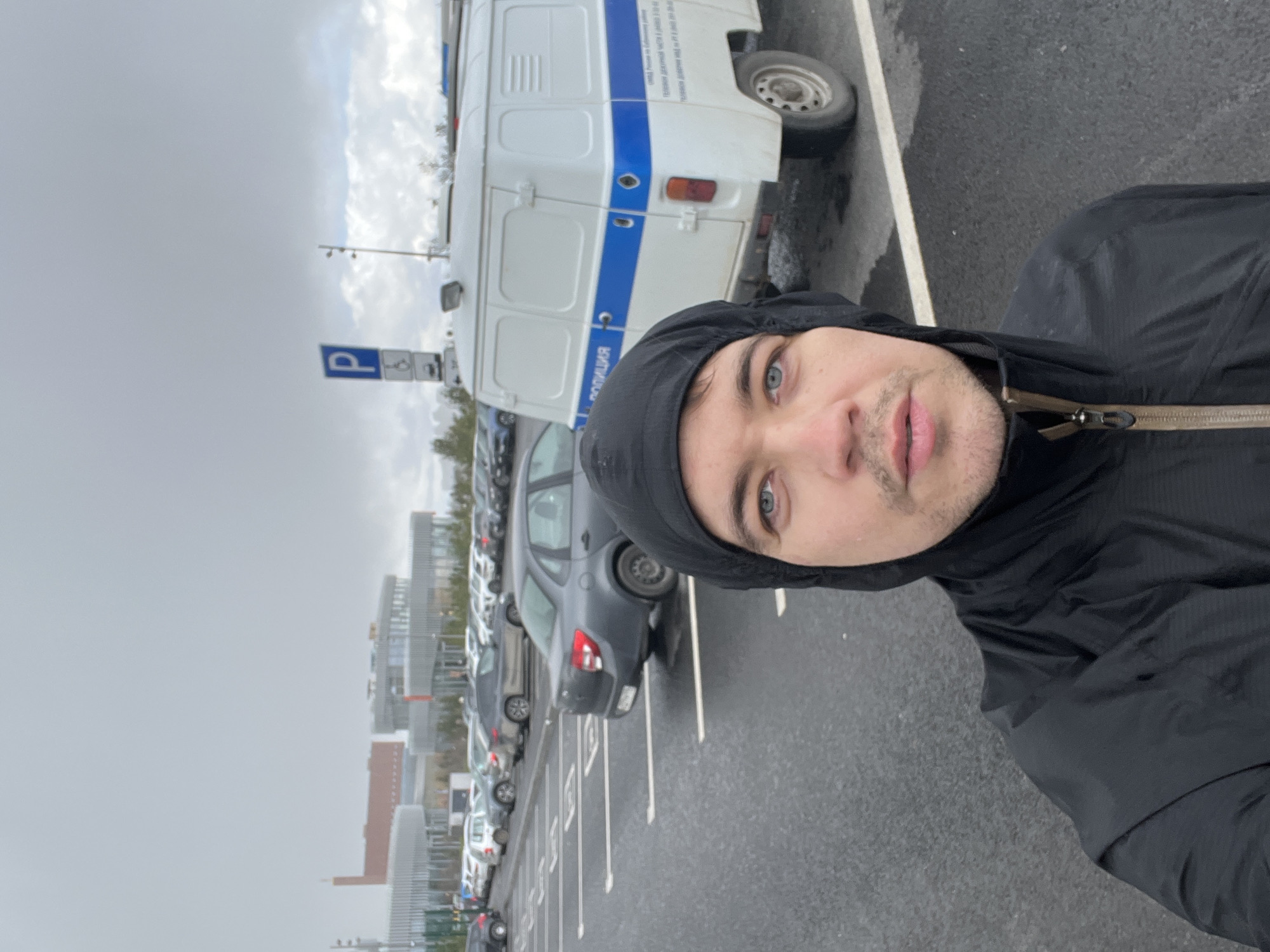 Man Takes Selfie Near Police Van in Kazan Parking Lot