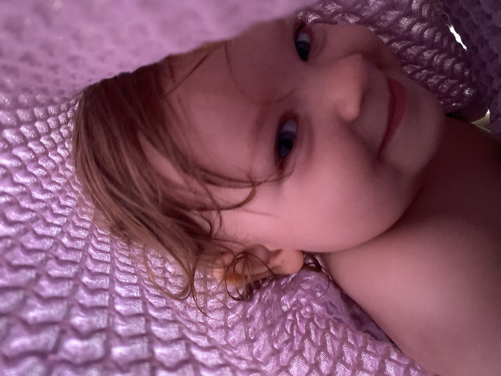 Child enjoys decorated chocolate strawberries under purple blanket