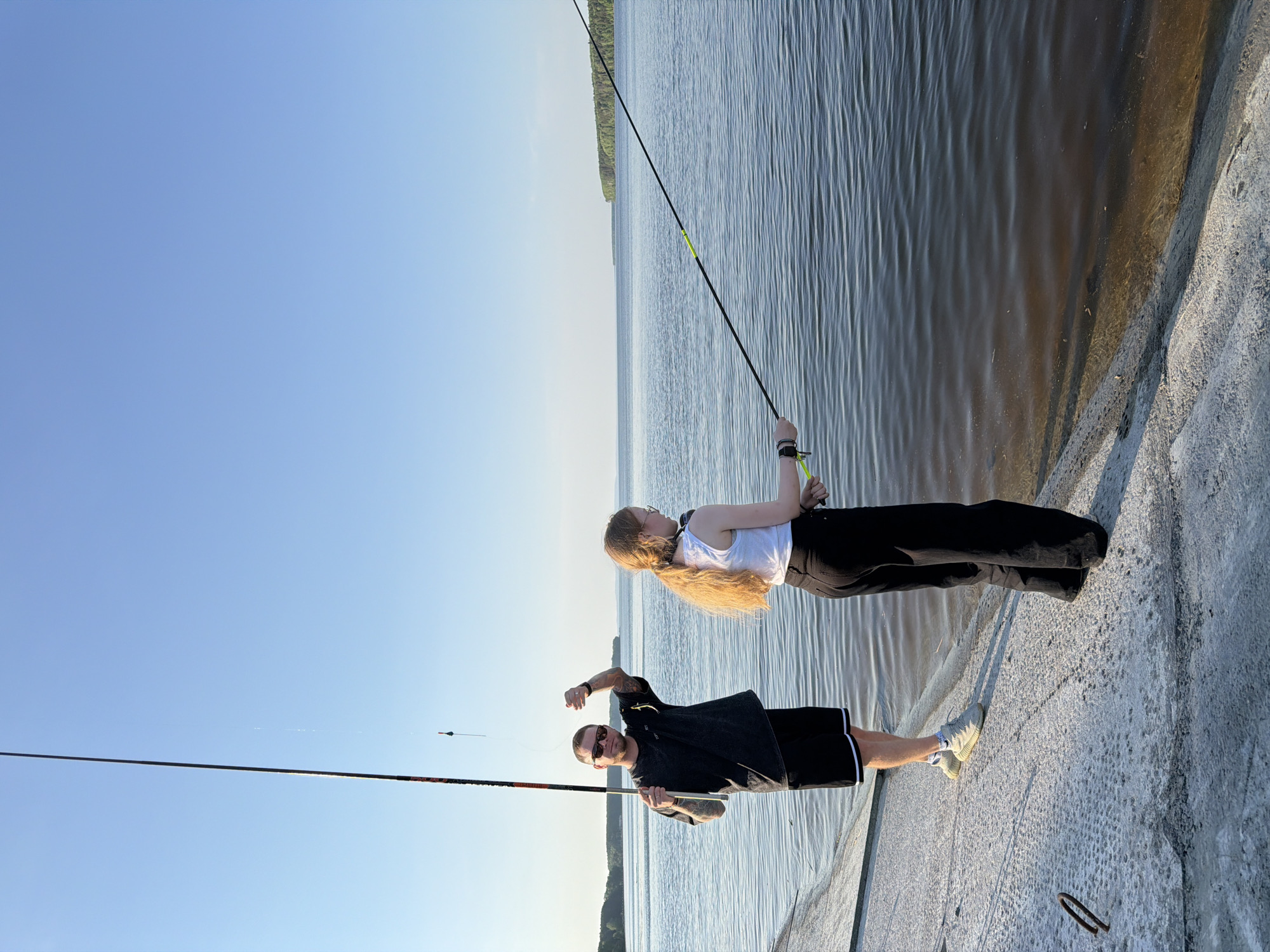Two anglers fish from concrete pier in Chaikovsky, Russia